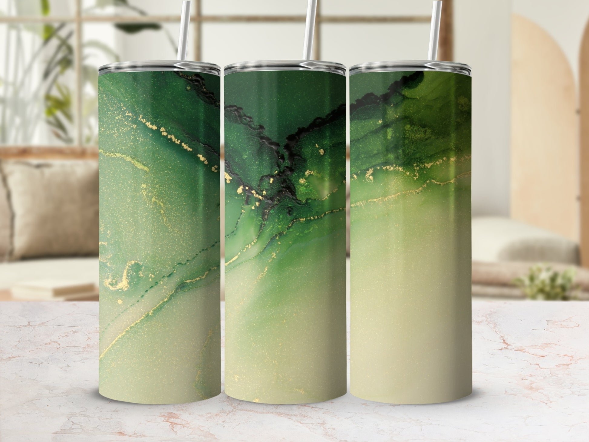 Green and gold abstract pattern on three tumblers with straws.