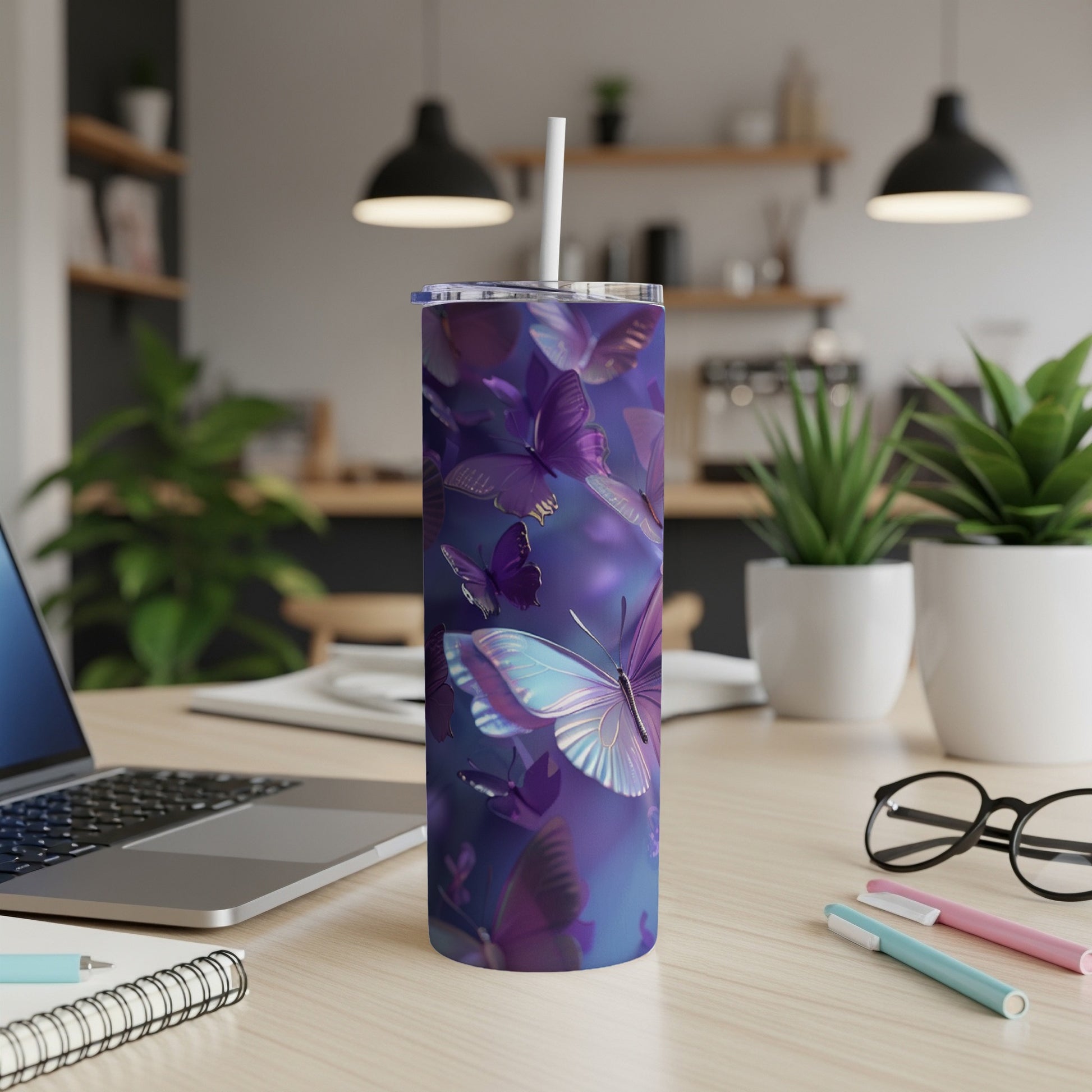 Purple butterflies on a blue background adorn a tall, slender tumbler with a straw.