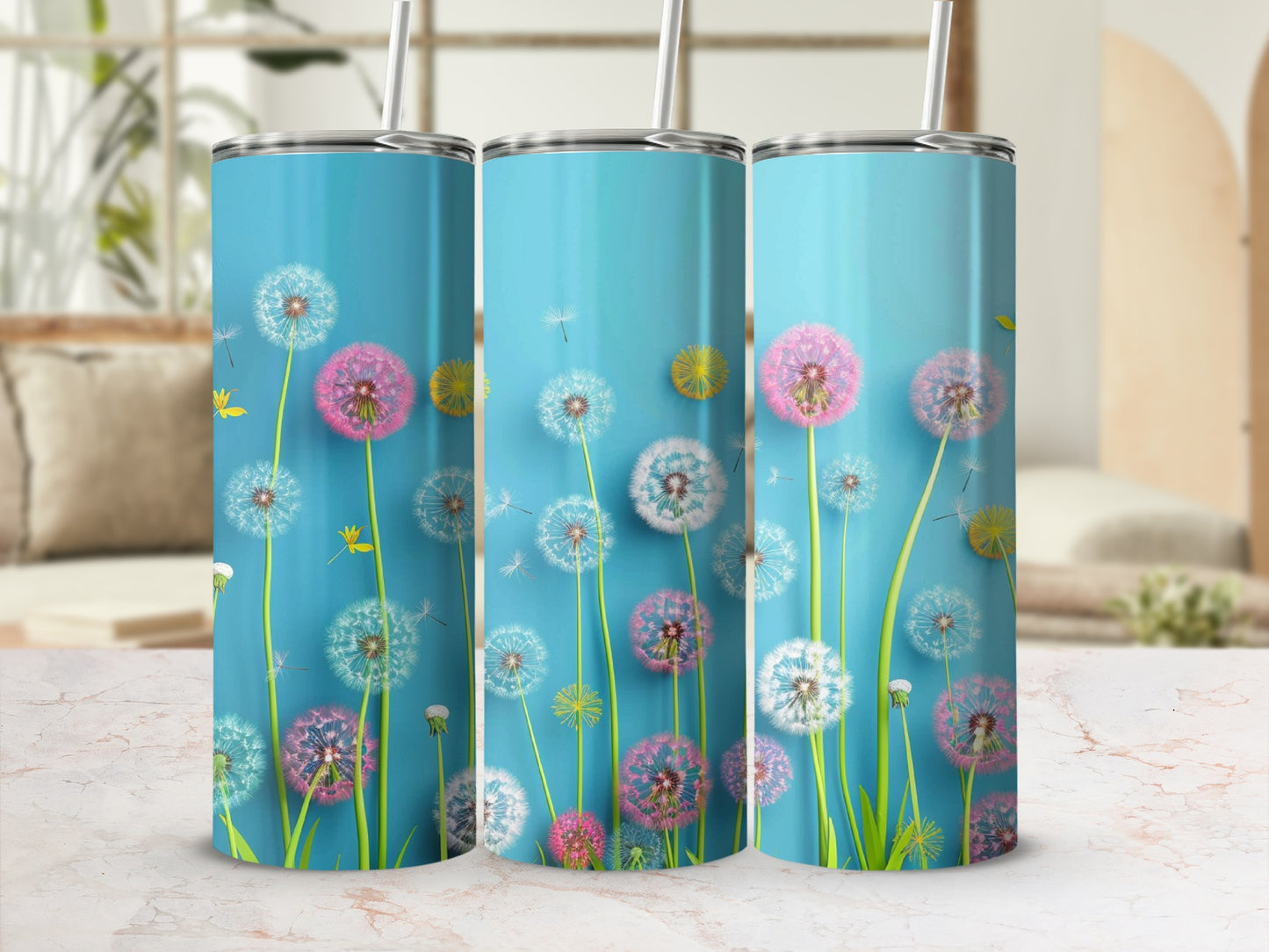 Three blue tumblers with dandelion designs and straws.