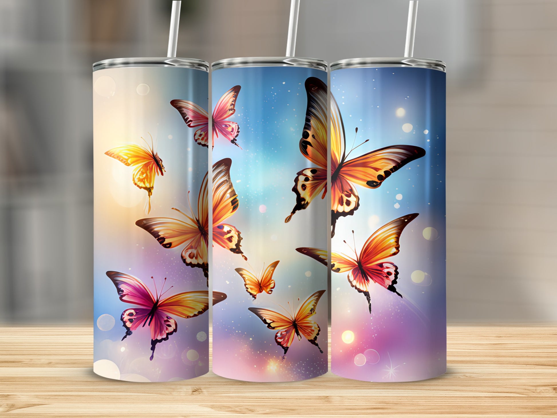 Three tumblers with colorful butterflies against a bokeh background.