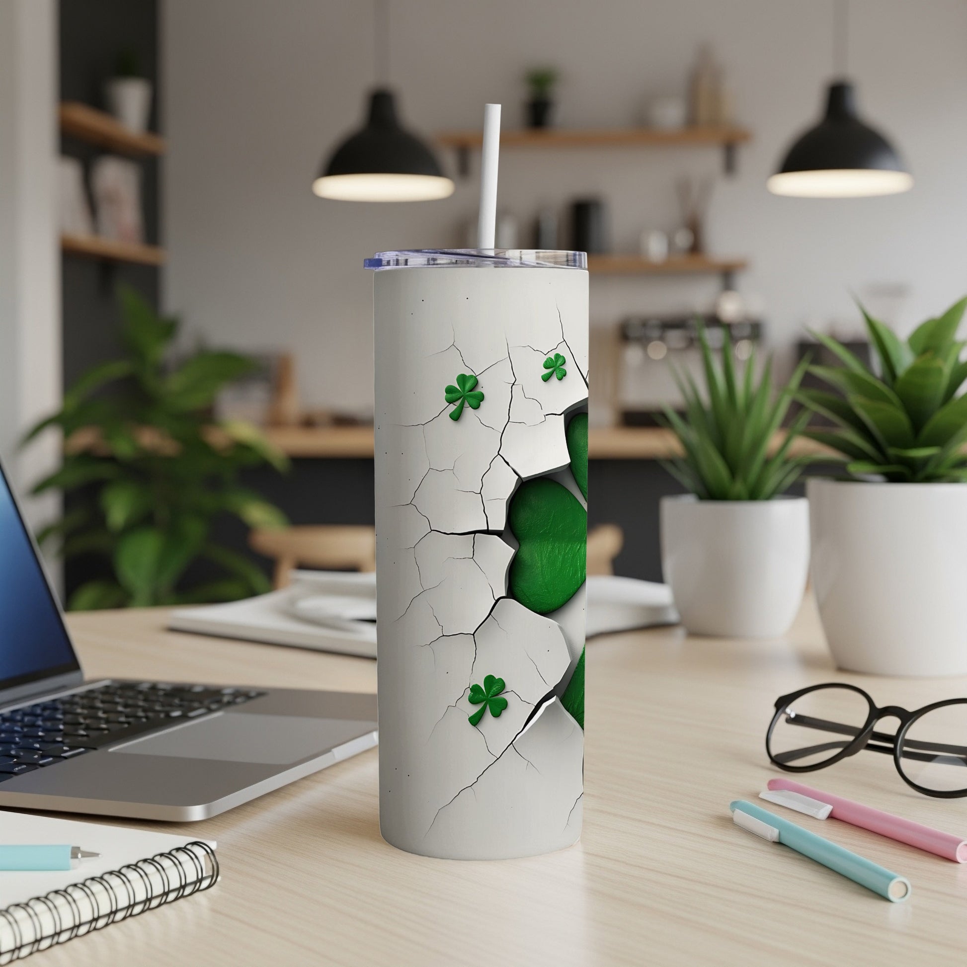 White tumbler with cracked pattern and green shamrocks, straw inserted.