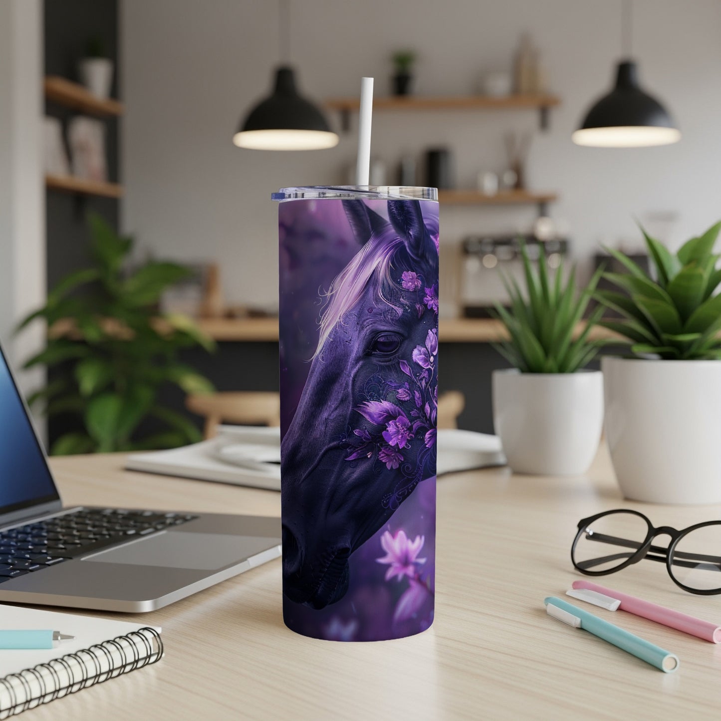 Dark horse head with floral accents on a purple tumbler, on a desk.