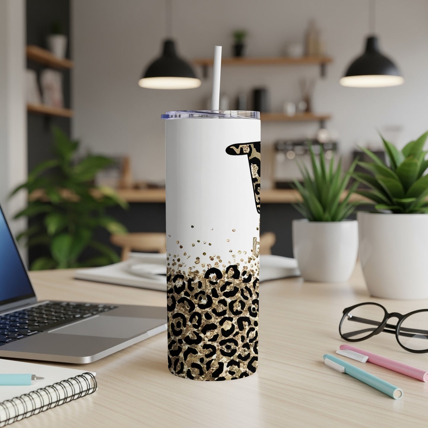 White tumbler with leopard print, gold glitter accents, and a black initial.