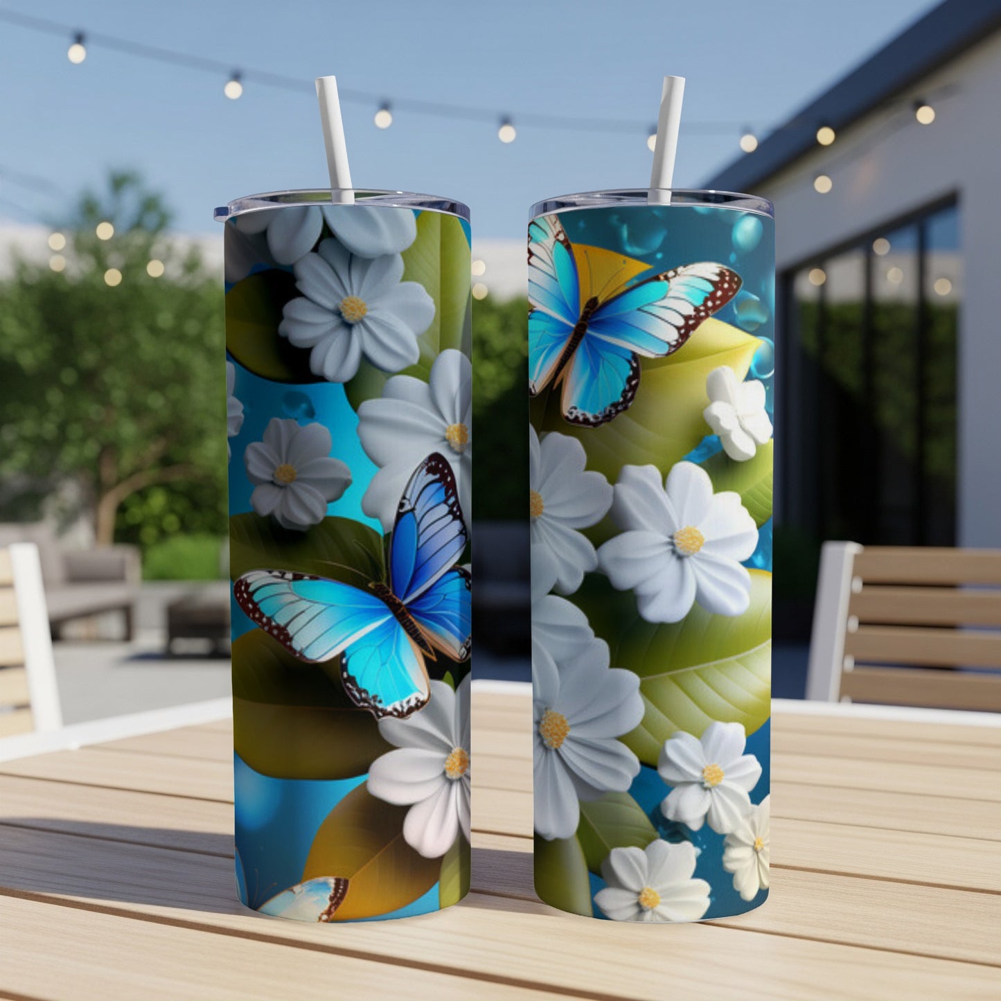 Two tumblers with blue butterflies and white flowers on a table.
