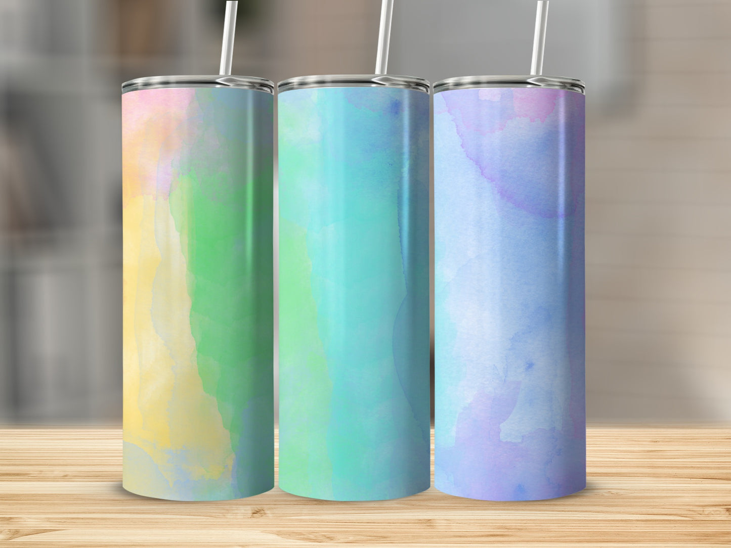 Three tumblers with watercolor patterns in yellow, green, and purple.