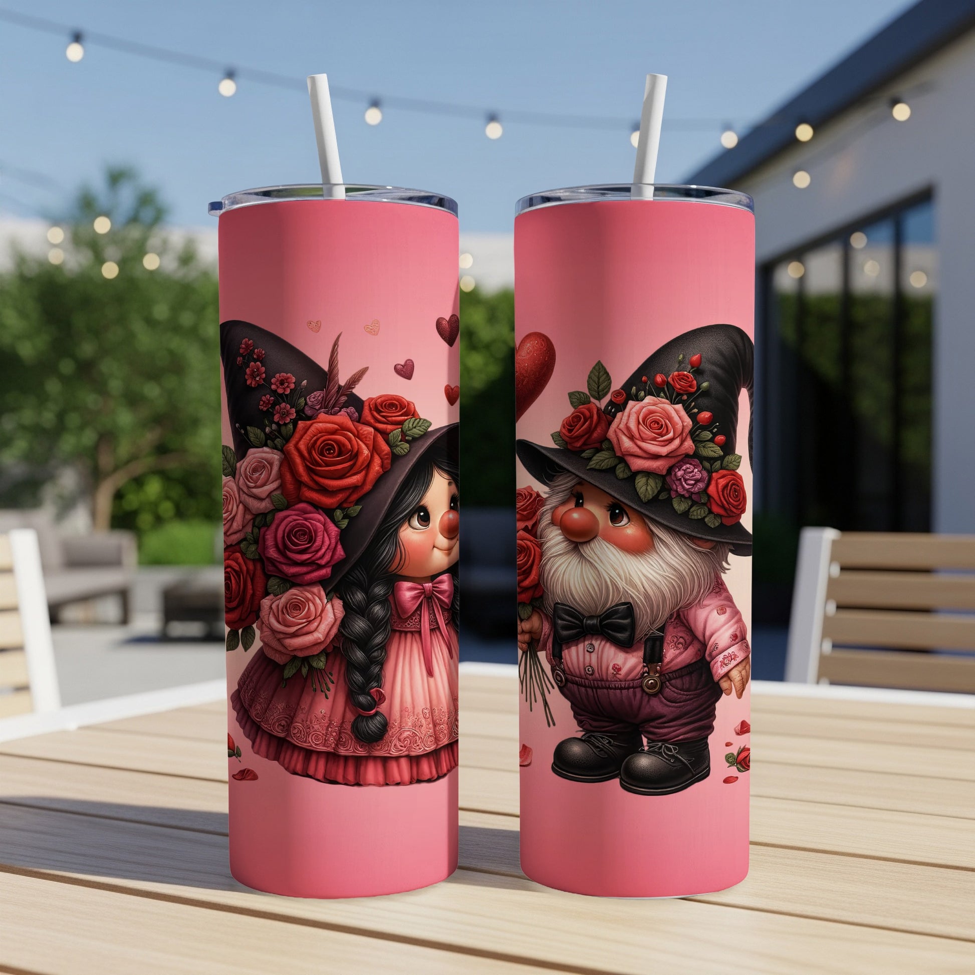 Two pink tumblers with gnome couple wearing hats adorned with roses.