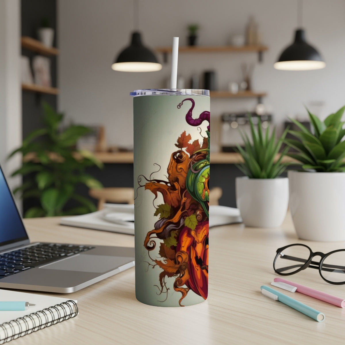 Tall tumbler with a Halloween pumpkin and leaf design and straw.