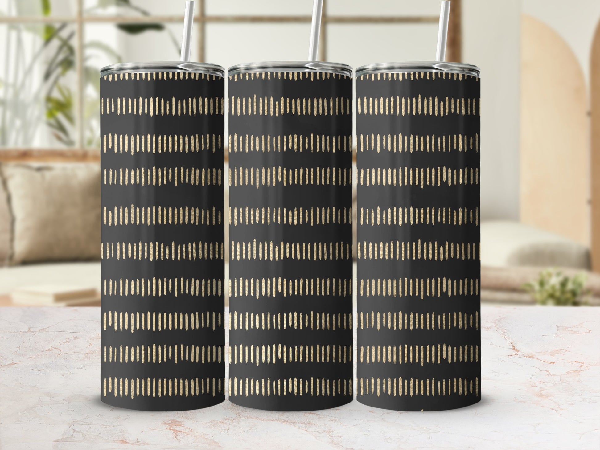 Three black tumblers with gold dashed stripe pattern and silver straws.
