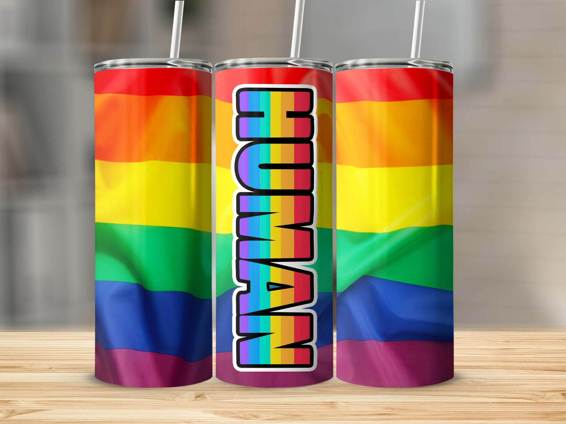 Rainbow flag tumbler with "HUMAN" text in colorful block letters.