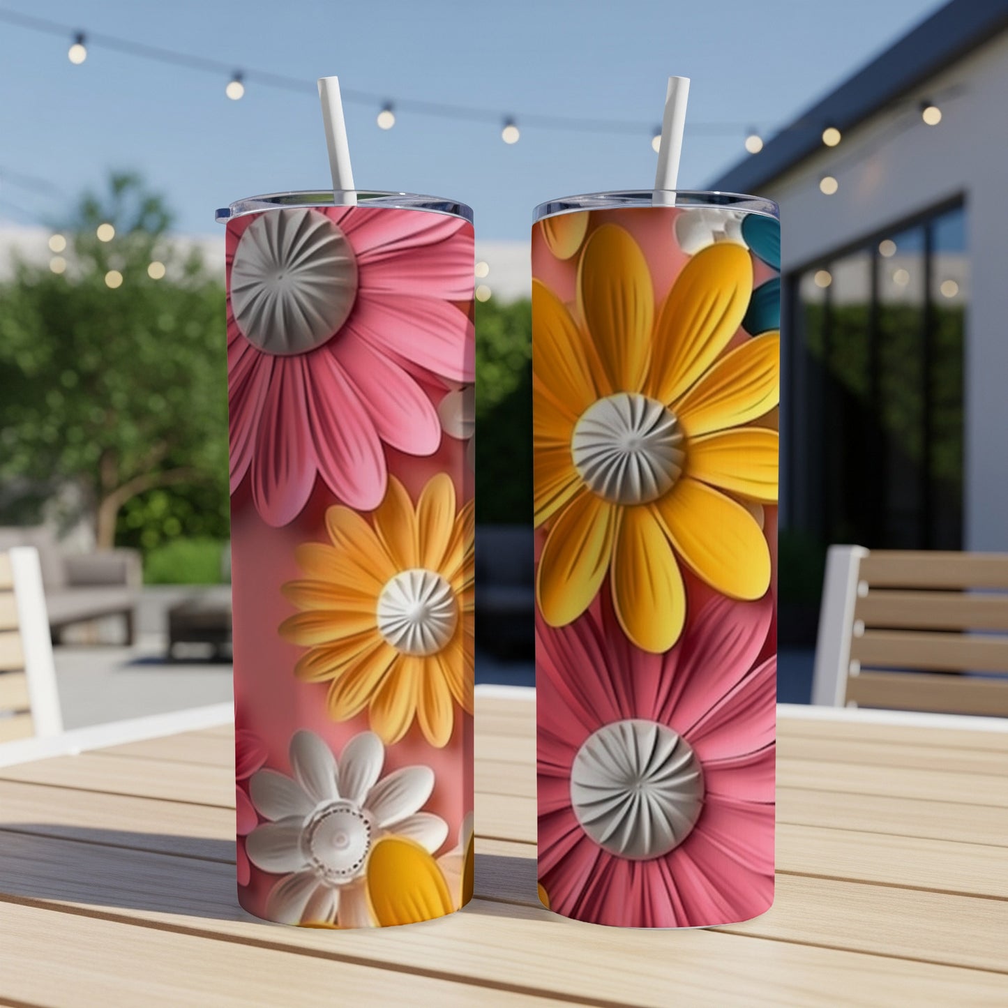 Two tumblers with colorful daisy floral designs on a wooden table.