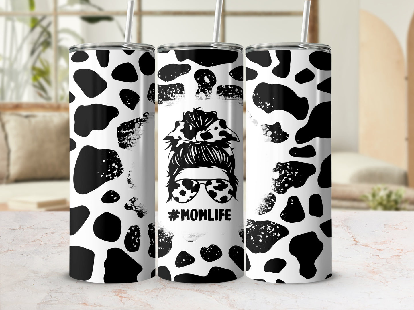 Black and white cow print tumbler with #MOMLIFE design.