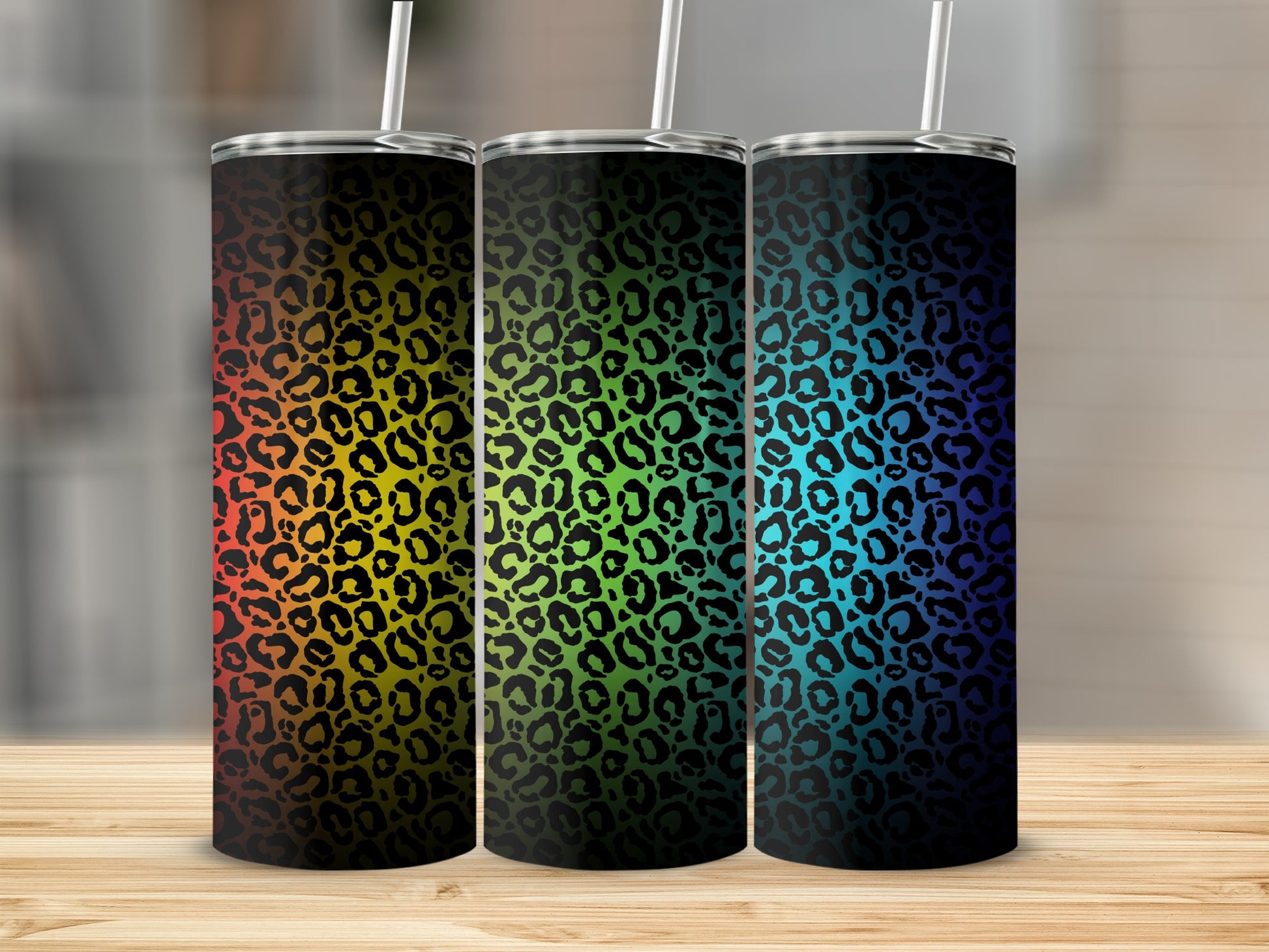 Three tumblers with rainbow and gradient leopard print designs.