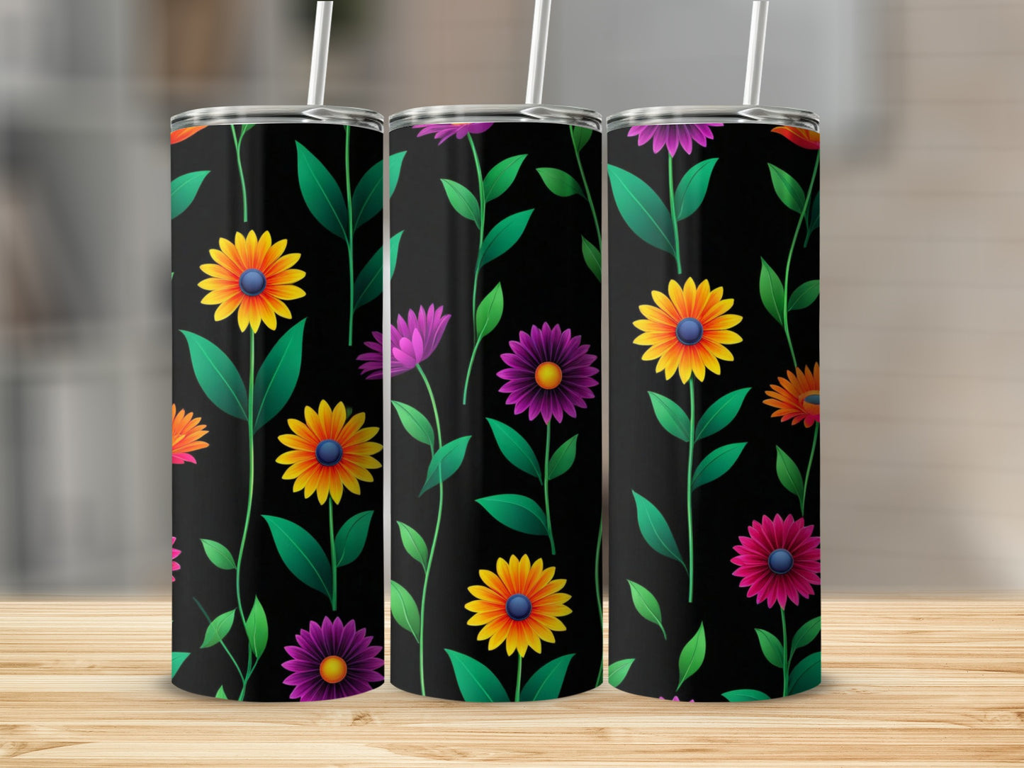Three black tumblers with colorful floral patterns on a wooden surface.