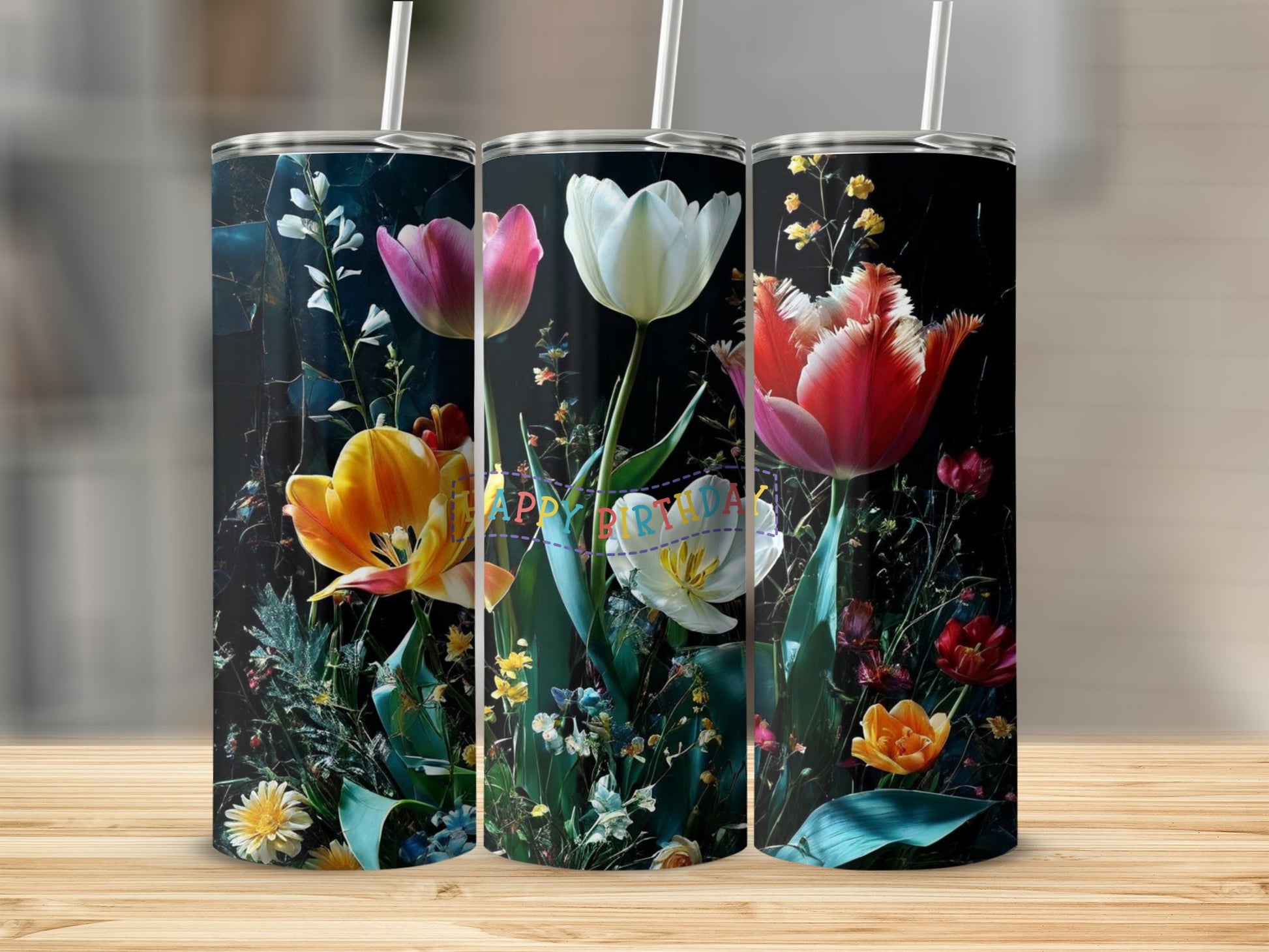 Three tumblers with a floral design of tulips and wildflowers on a dark background.