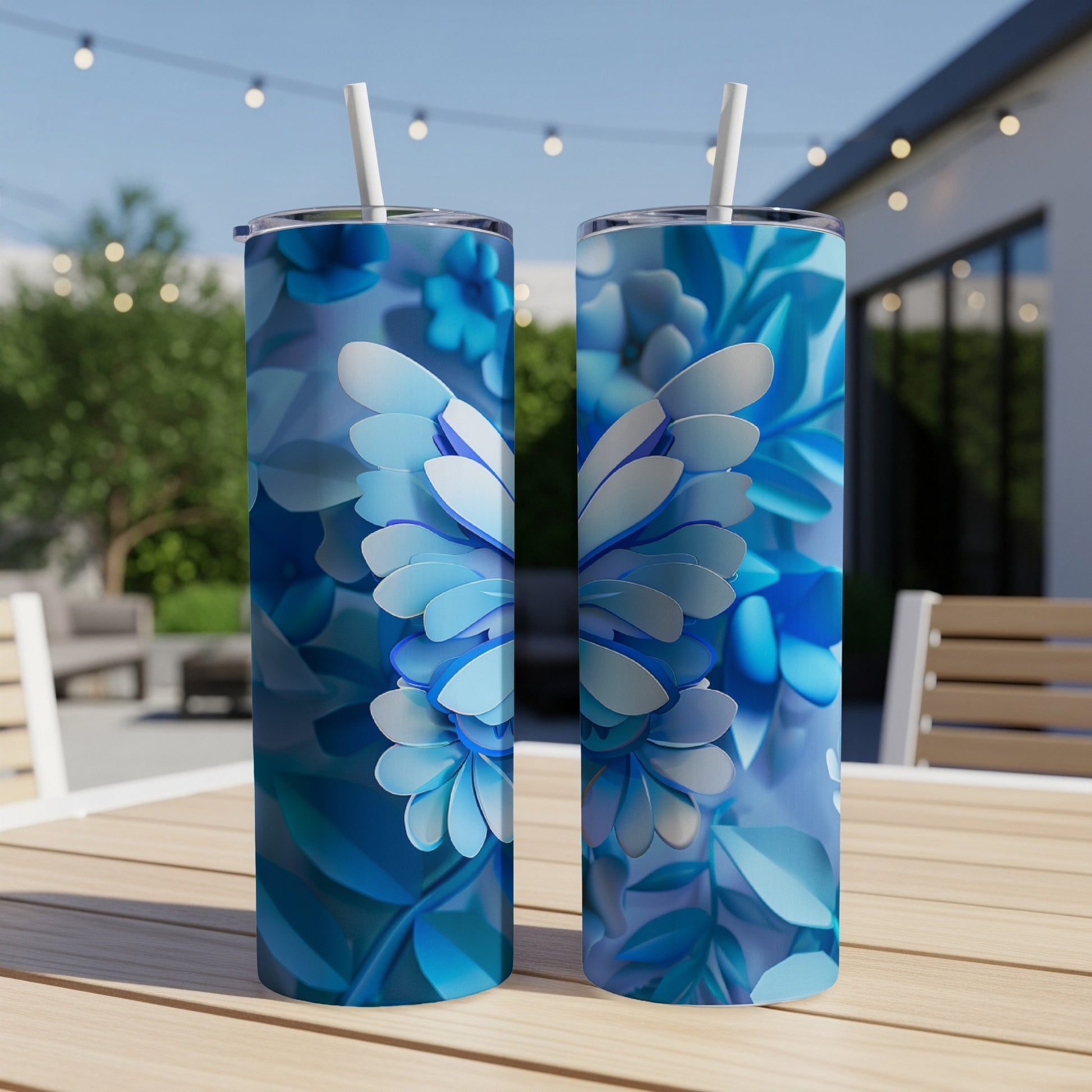 Two blue butterfly-themed tumblers with straws on a table outdoors.