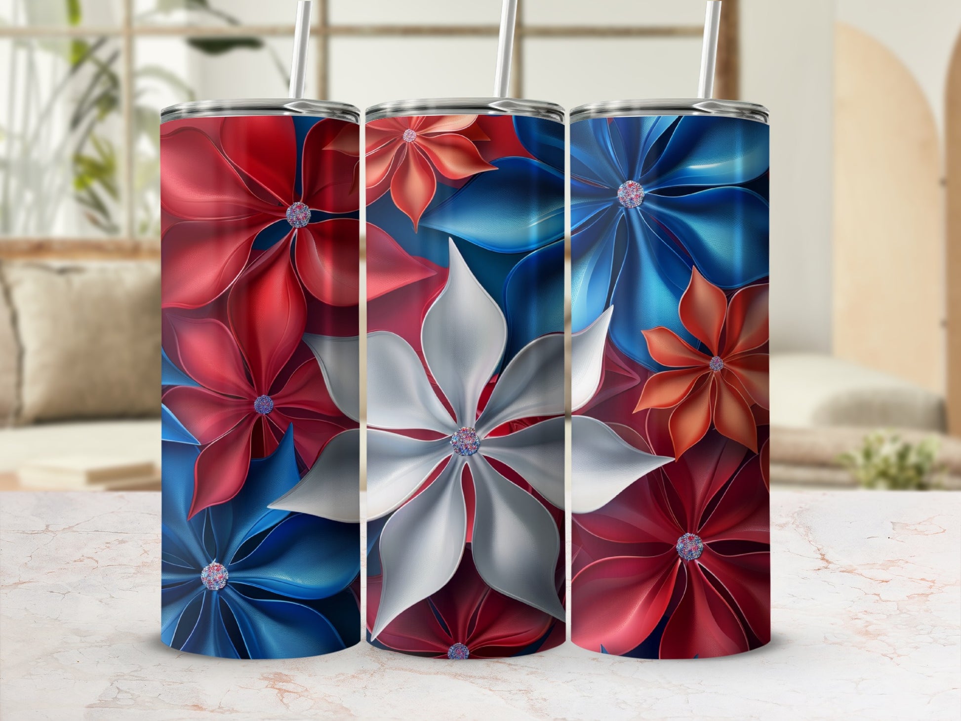 Three tumblers with red, white, and blue floral designs and straws.