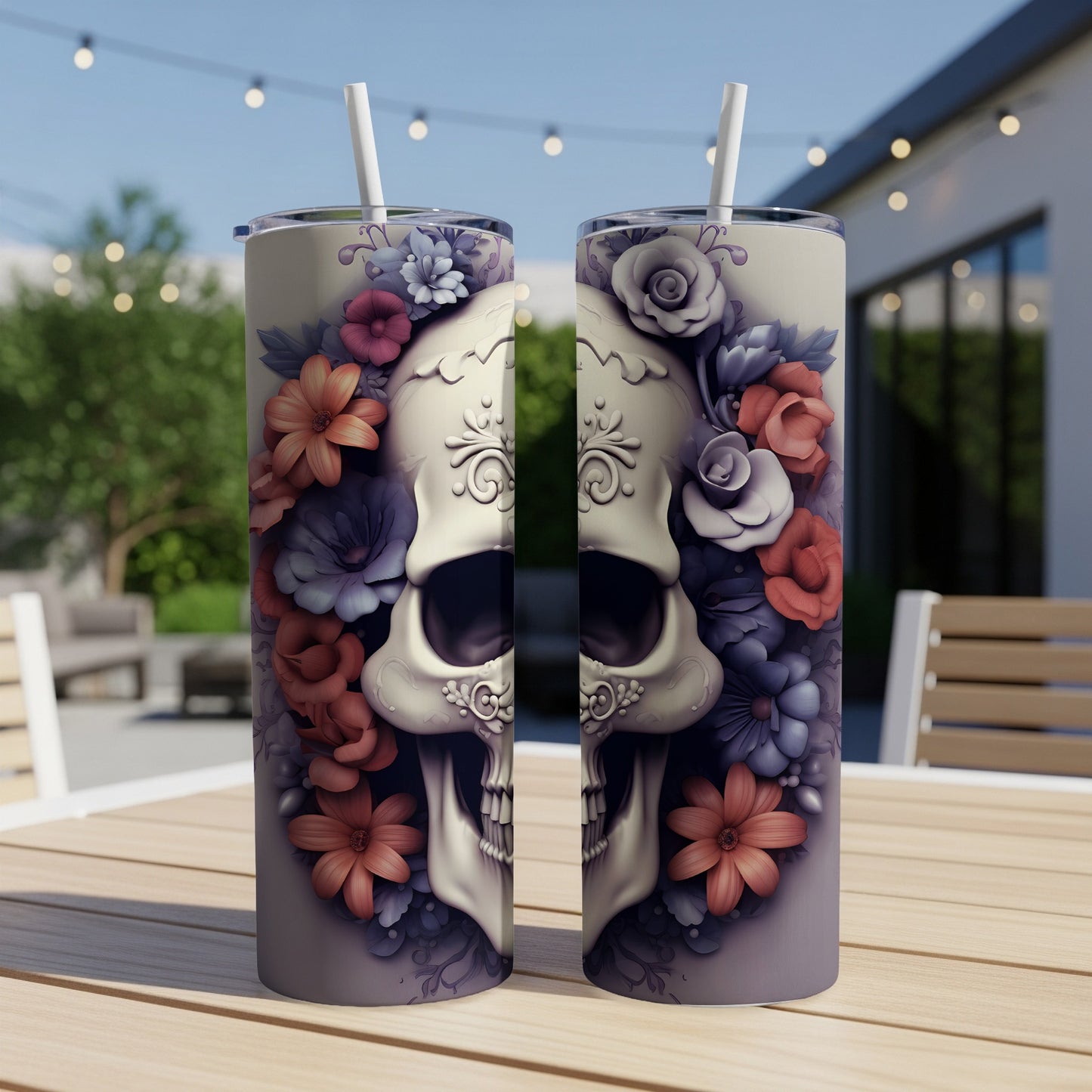 Sugar skull design with floral accents on two stainless steel tumblers.