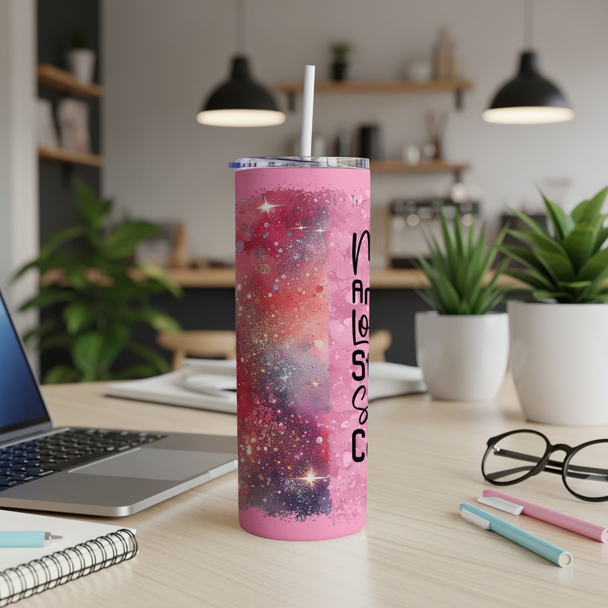 Pink glitter tumbler with "Nurse Life" text, on a desk with laptop.