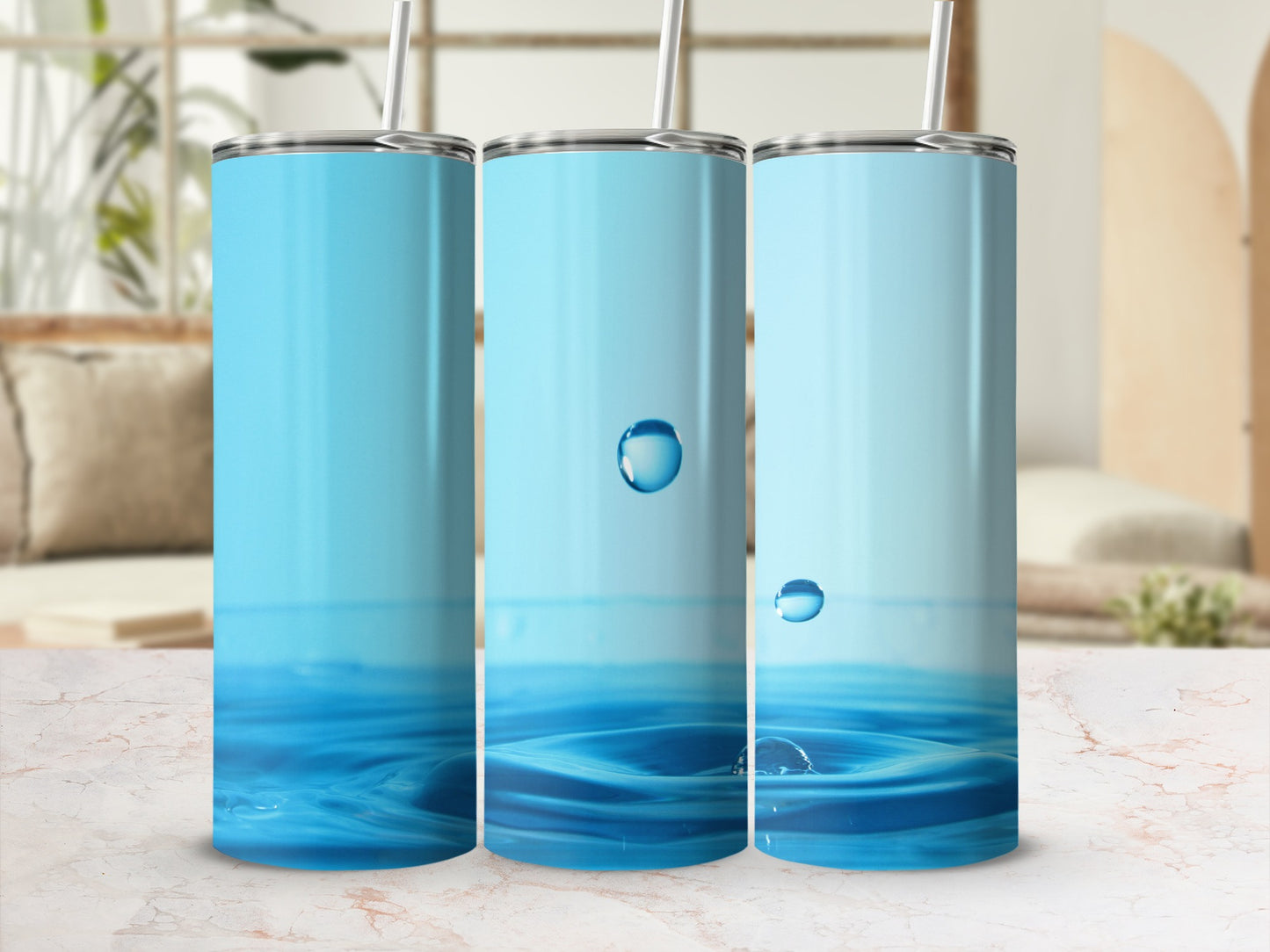 Three blue tumblers with water splash graphic and straws.