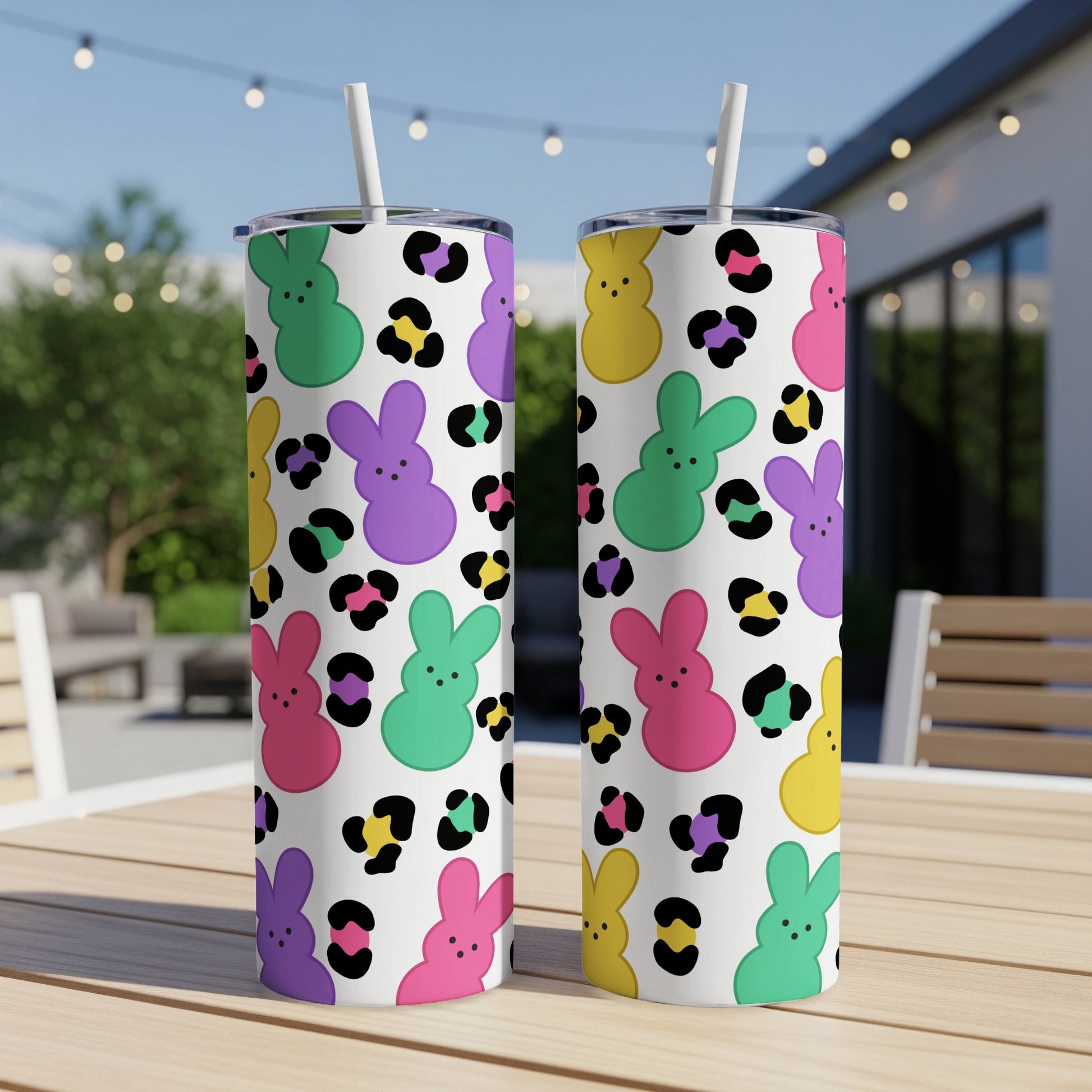 Two tall, skinny tumblers with a colorful bunny and leopard print pattern.