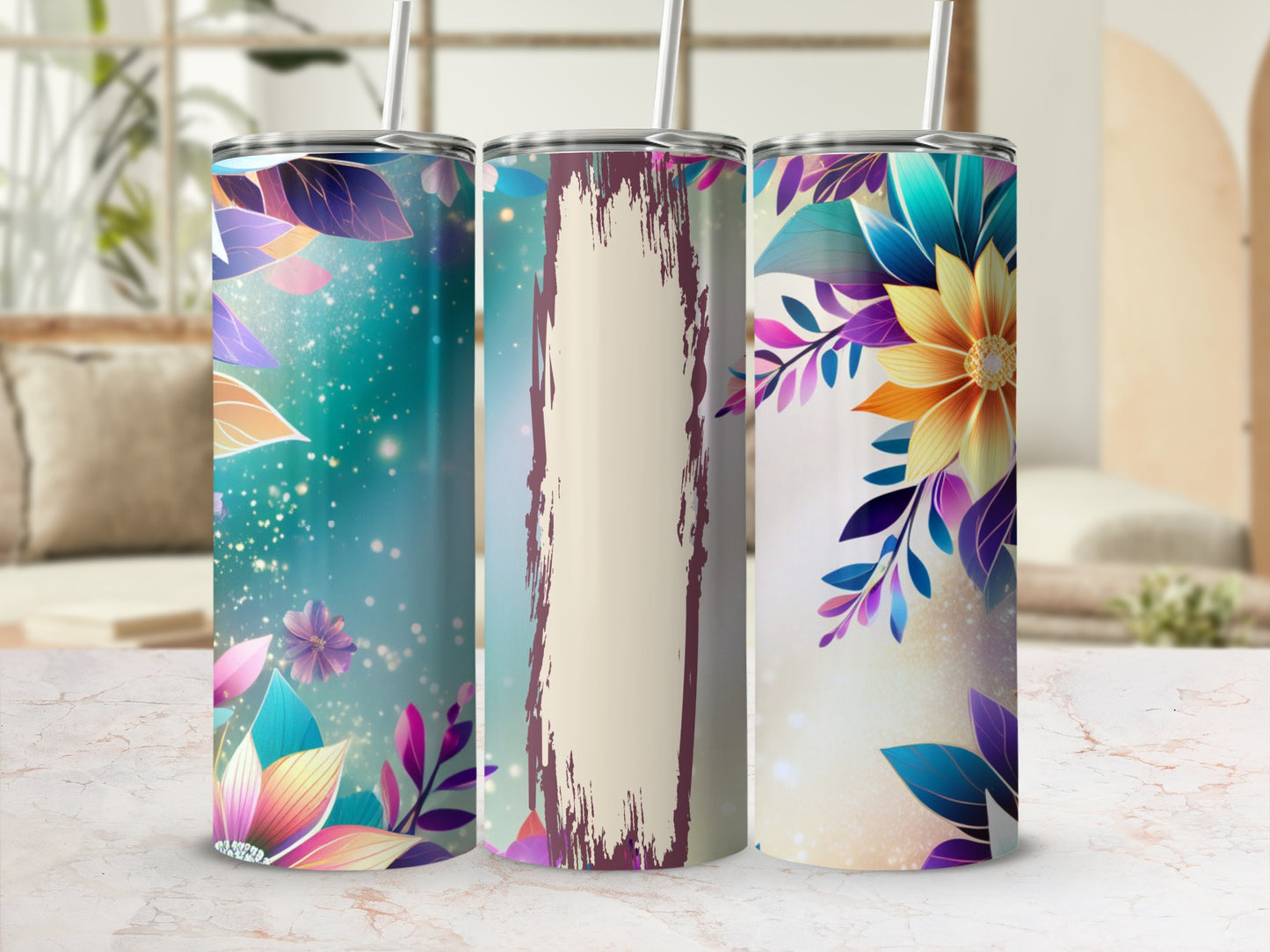 Three tall tumblers with floral designs and straw, displayed on a marble surface.