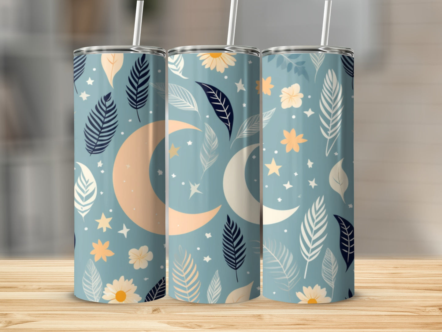 Three tumblers with a moon and floral pattern on a wooden surface.