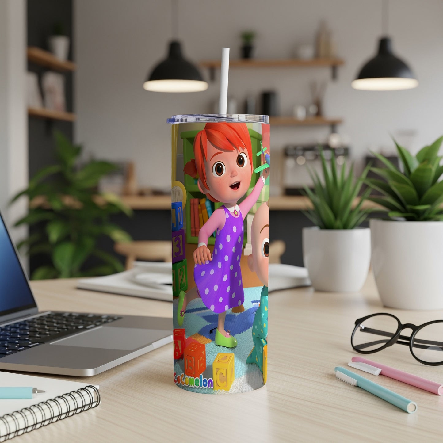 Cocomelon tumbler with characters JJ and YoYo on a desk.