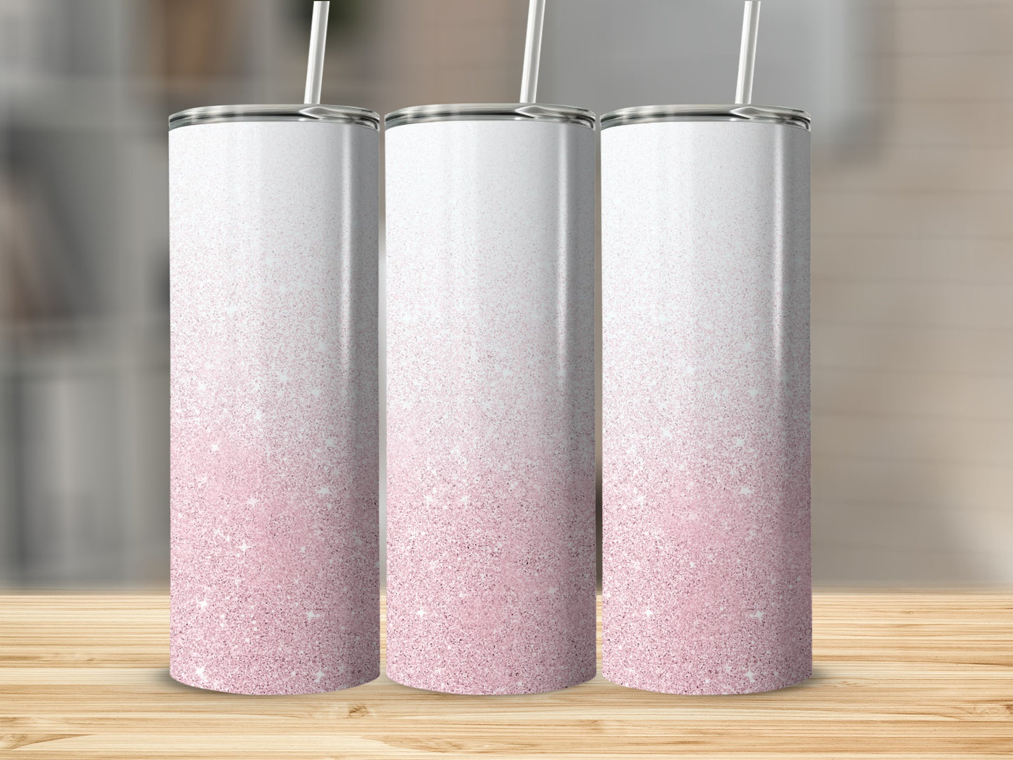Three white tumblers with pink glitter gradient and straws.