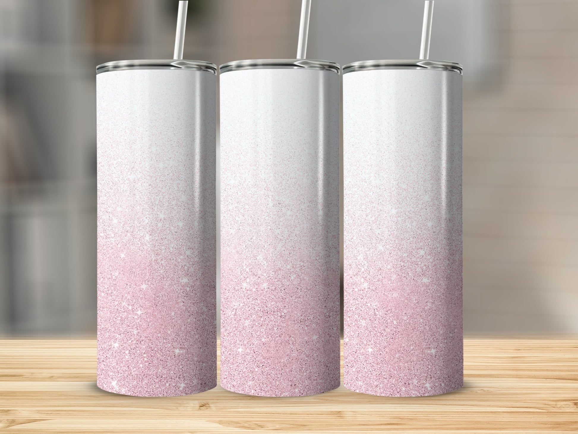 Three white tumblers with pink glitter gradient and straws.