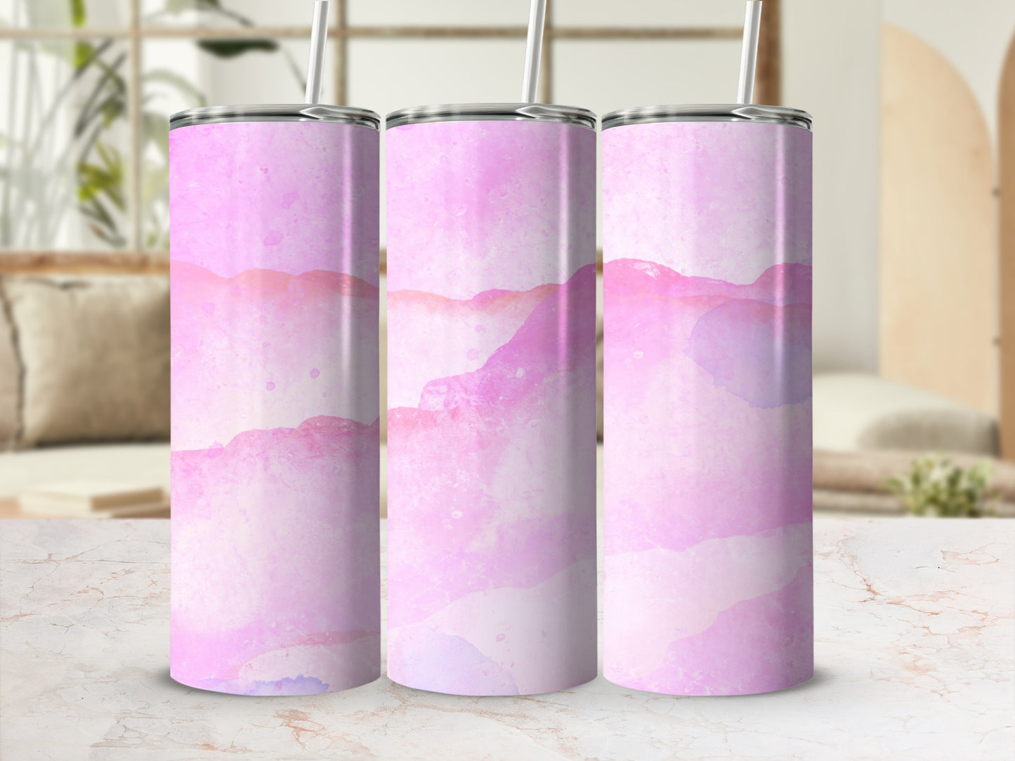 Three pink watercolor abstract pattern tumblers with straws, displayed on a marbled surface.