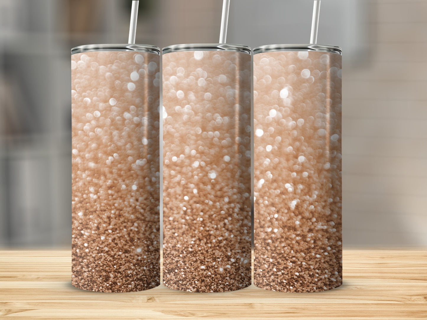 Three rose gold glitter tumblers with straws displayed on a wooden surface.