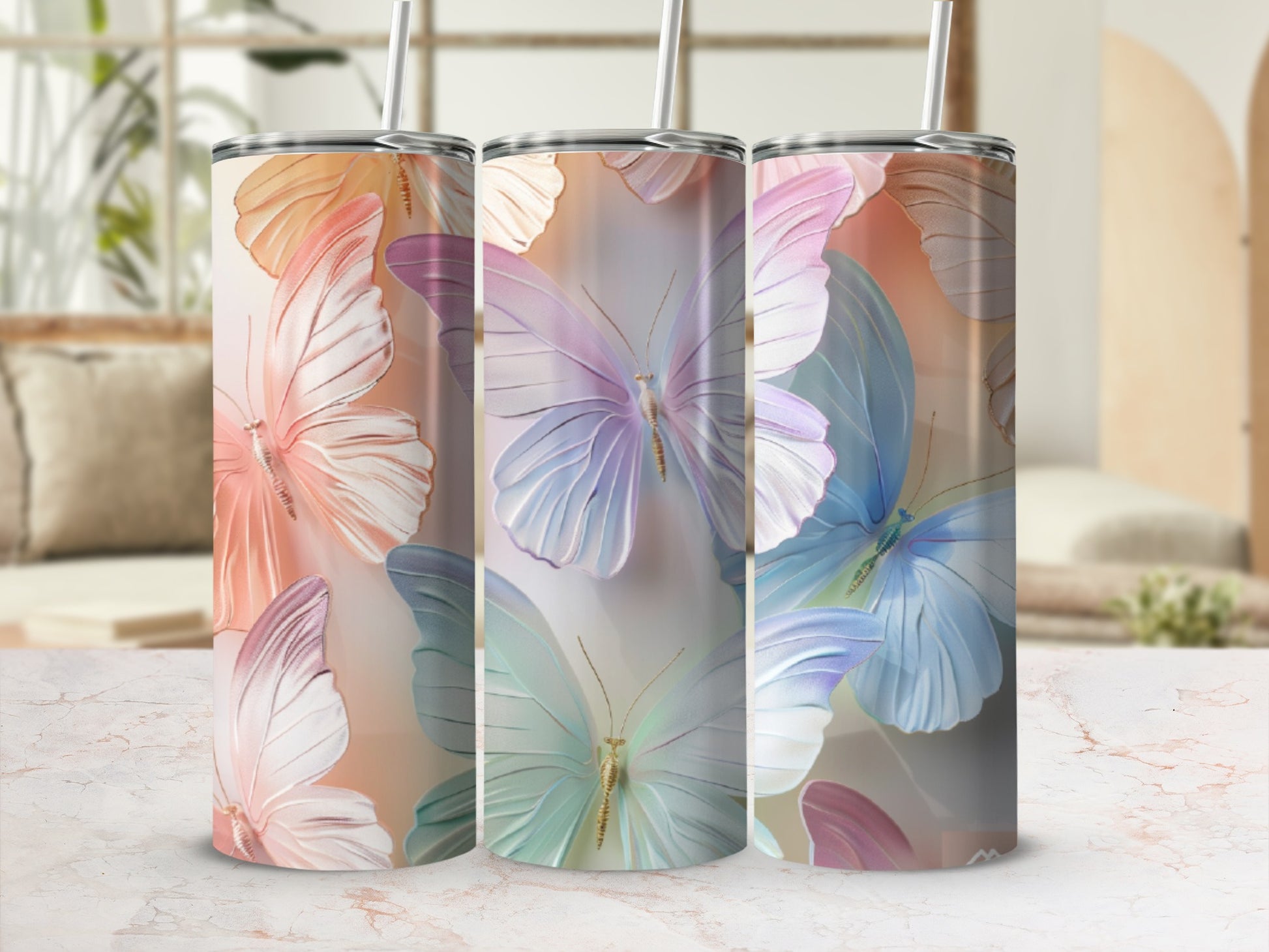 Three tumblers with iridescent butterfly designs on a countertop.