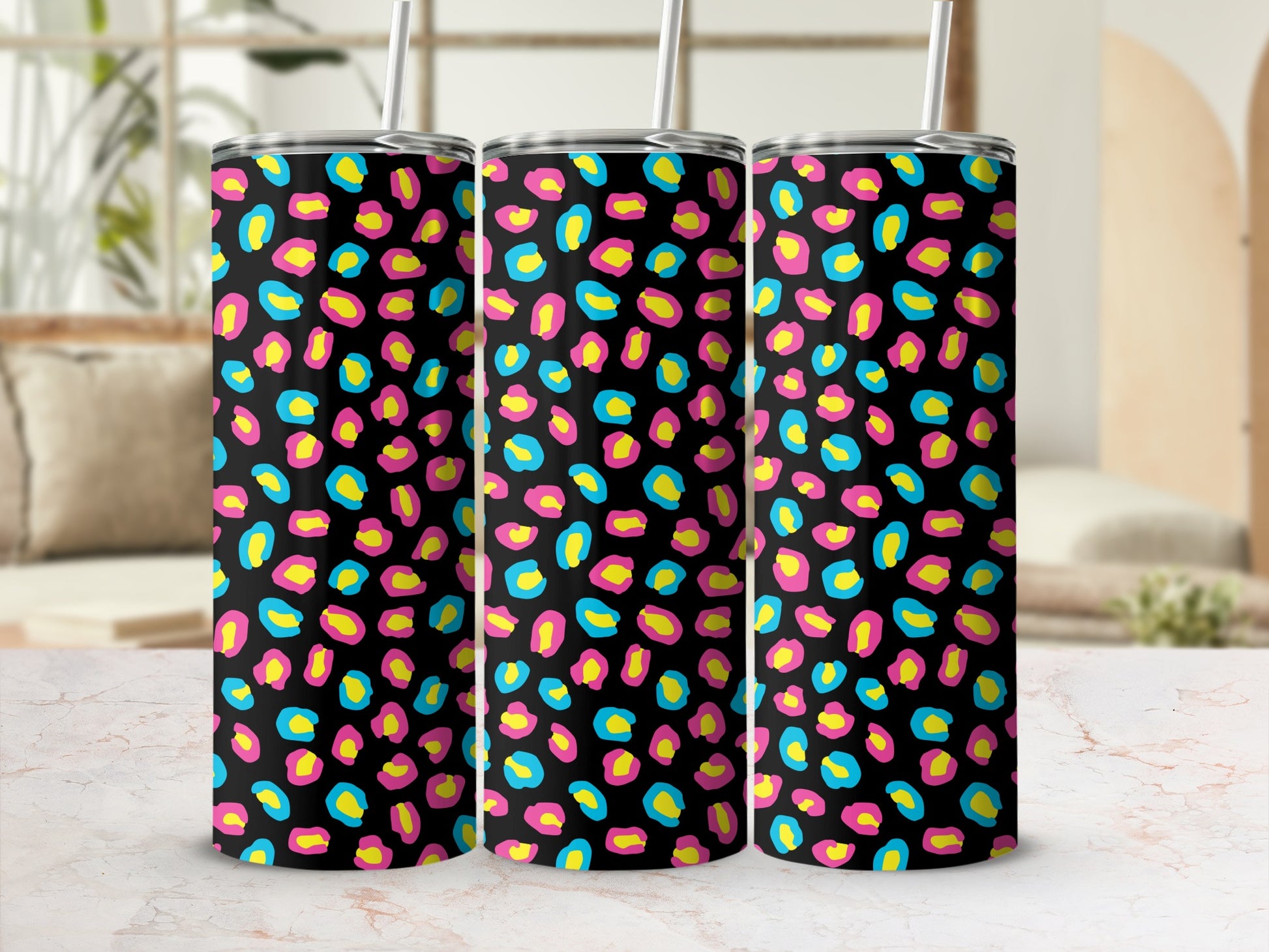 Three tumblers with a black background and a bright leopard print of pink, yellow, and blue.