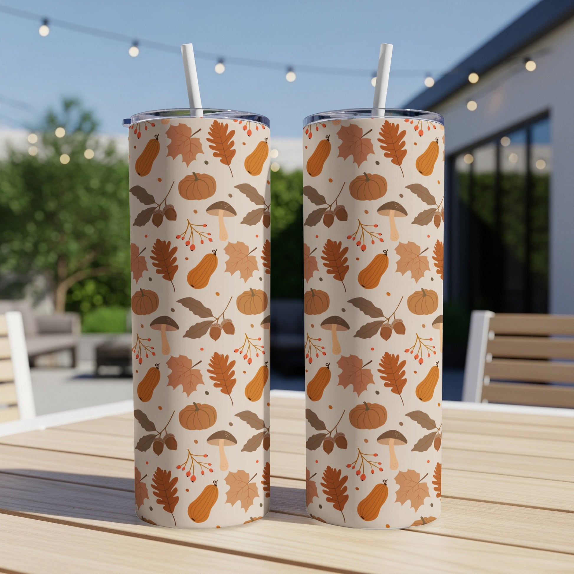 Two tumblers with a repeating pattern of autumn leaves, pumpkins, and mushrooms.