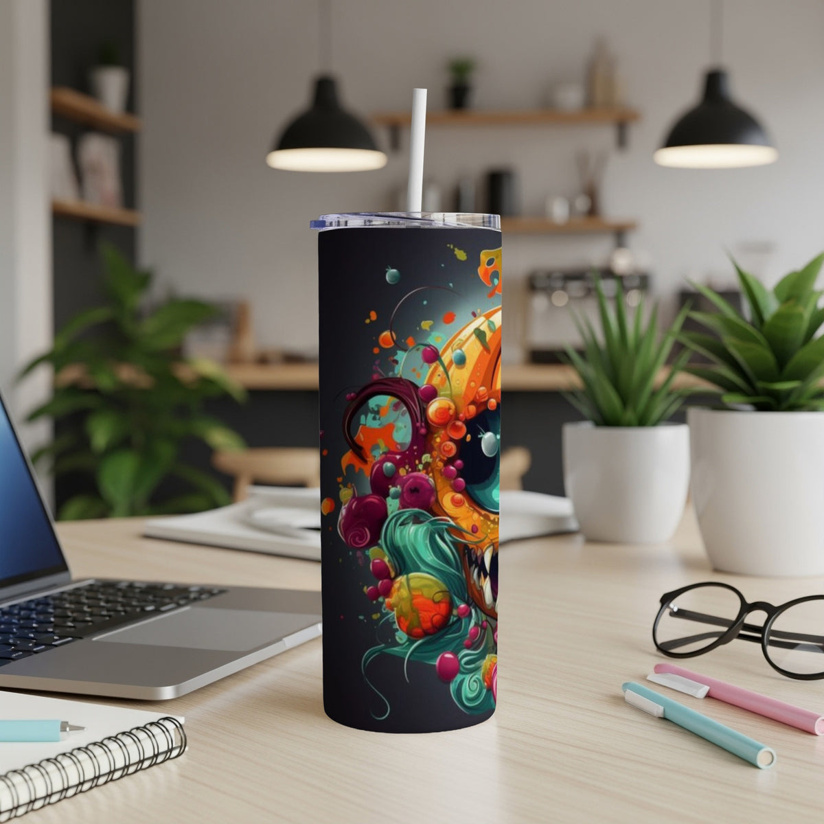 Black tumbler with a colorful abstract monster design and a white straw.