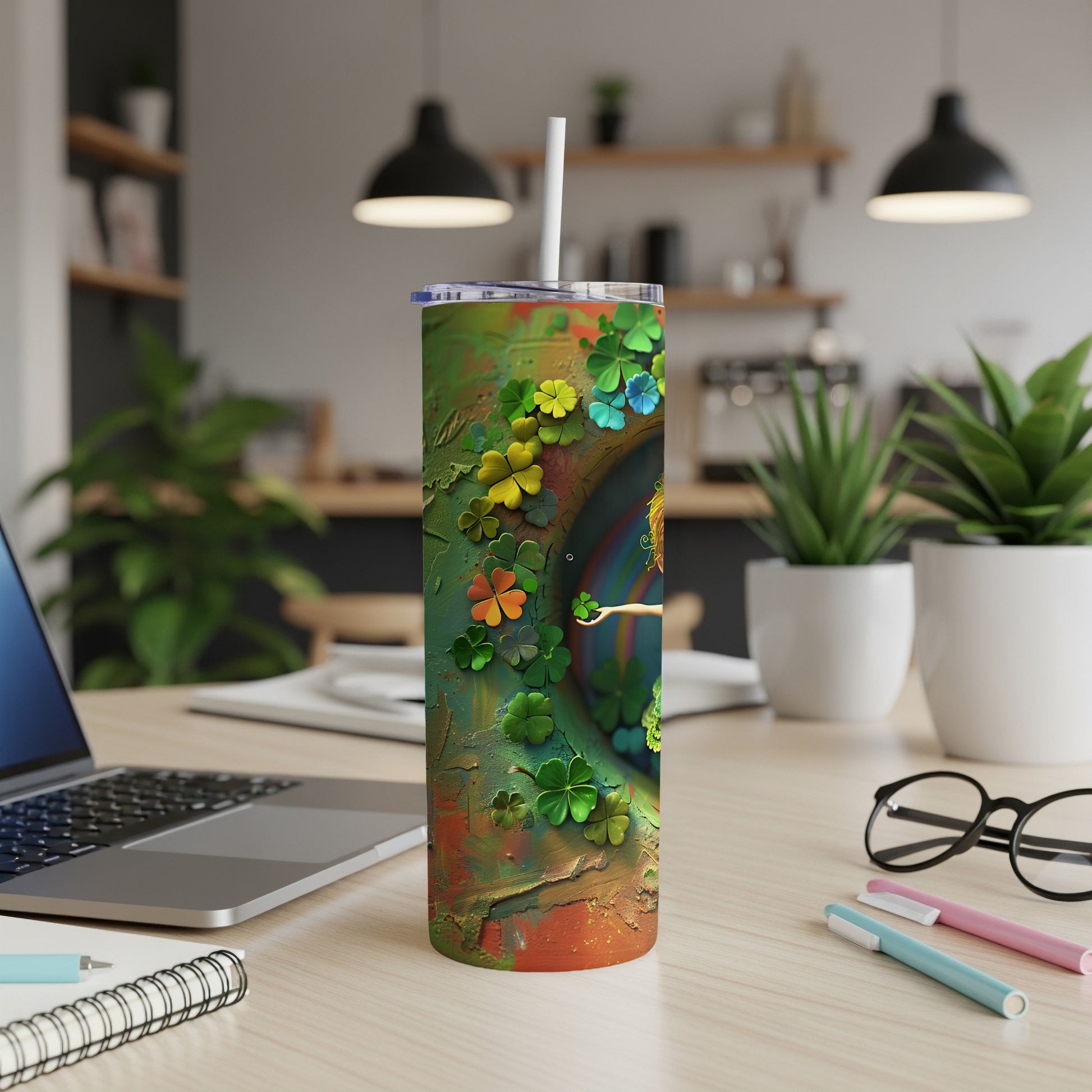 Green tumbler with shamrocks and a gold swirl on a desk.