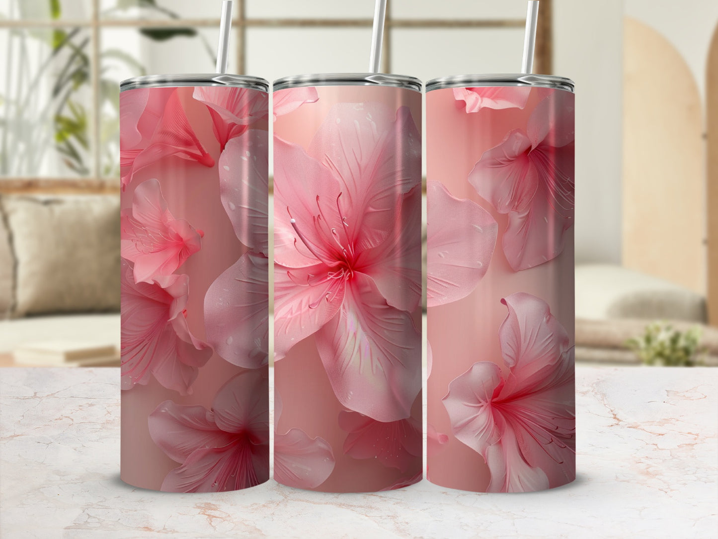 Three tall pink floral tumblers with straws on a marble surface.
