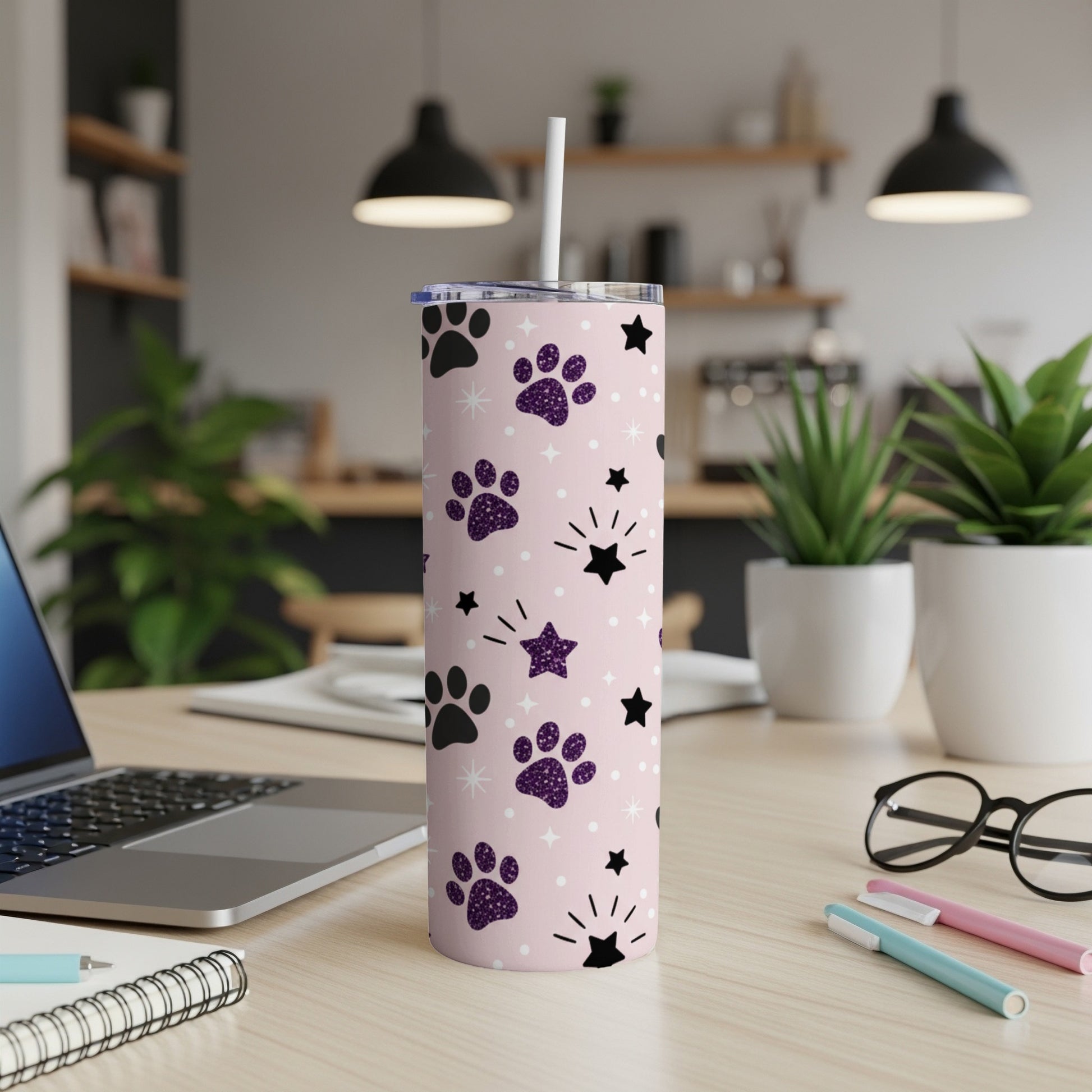 Pink tumbler with purple paw prints and white stars.