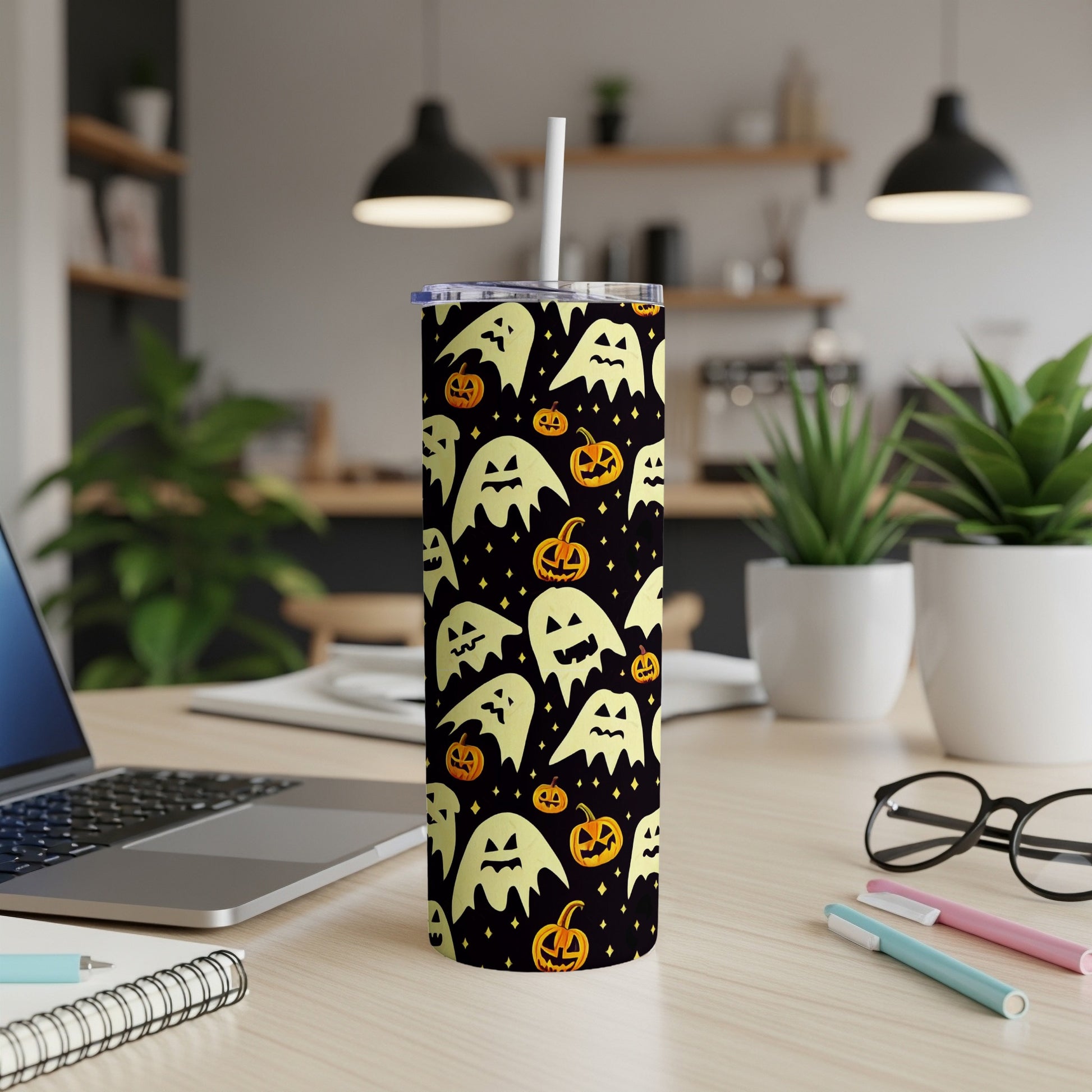 Tall tumbler with a black background featuring a pattern of yellow ghosts and orange pumpkins.