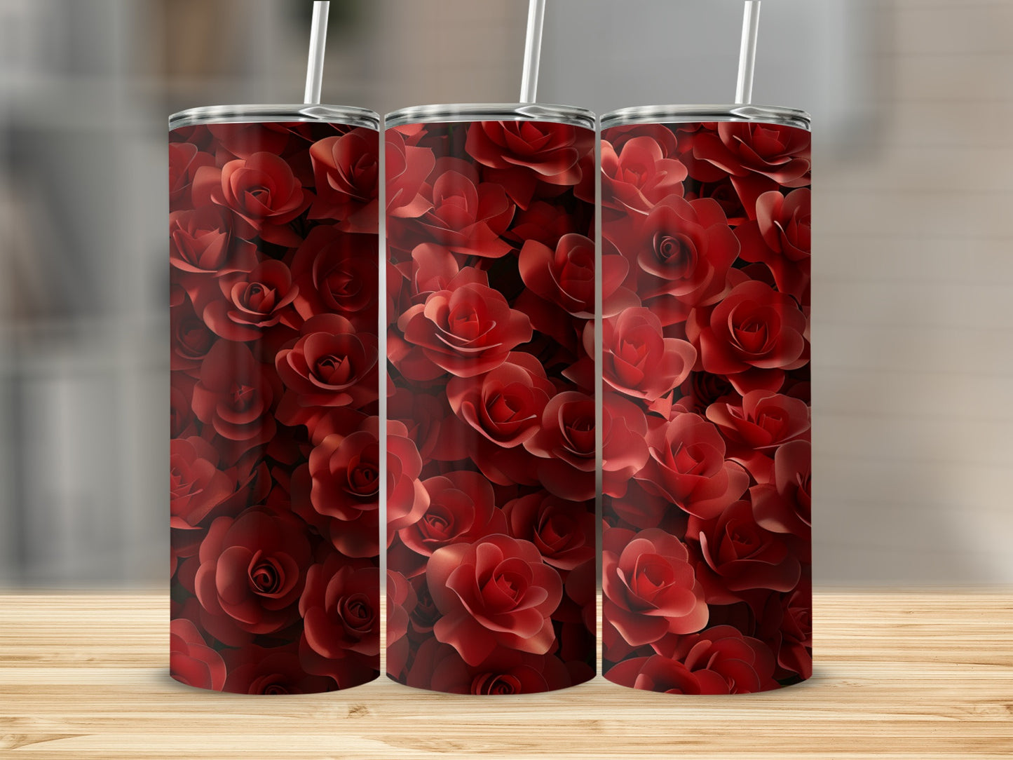 Three tumblers with a repeating pattern of red roses on a wooden surface.