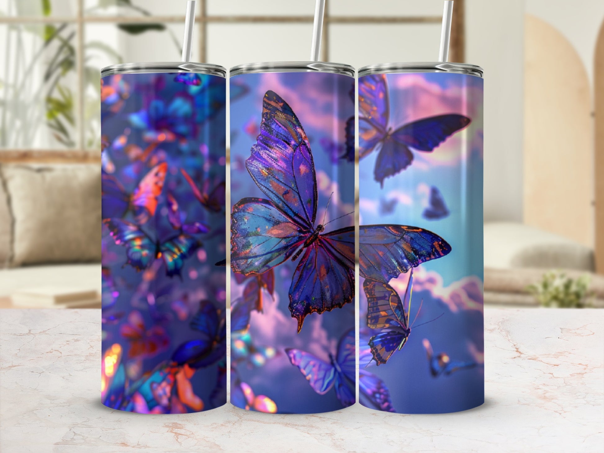 Three tumblers with colorful butterflies on a marbled surface.