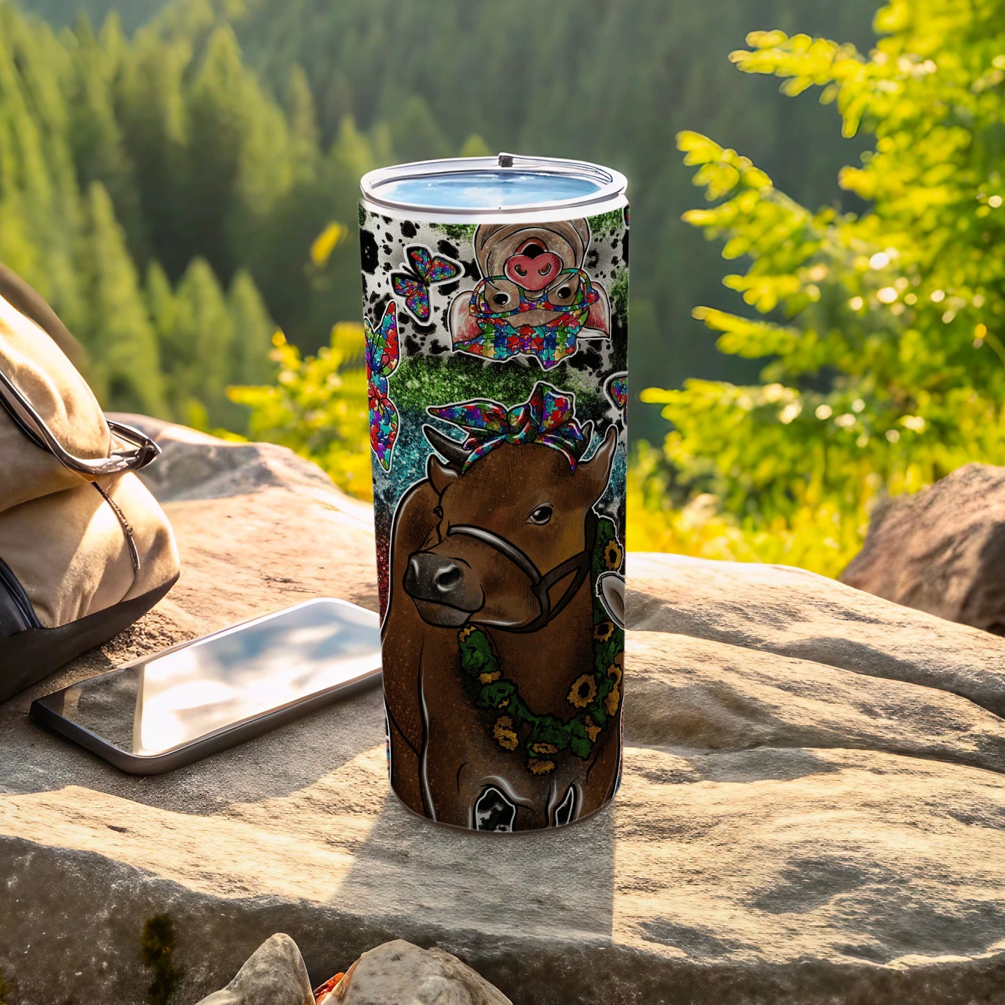 Cow with flower lei and butterflies on a decorated tumbler.