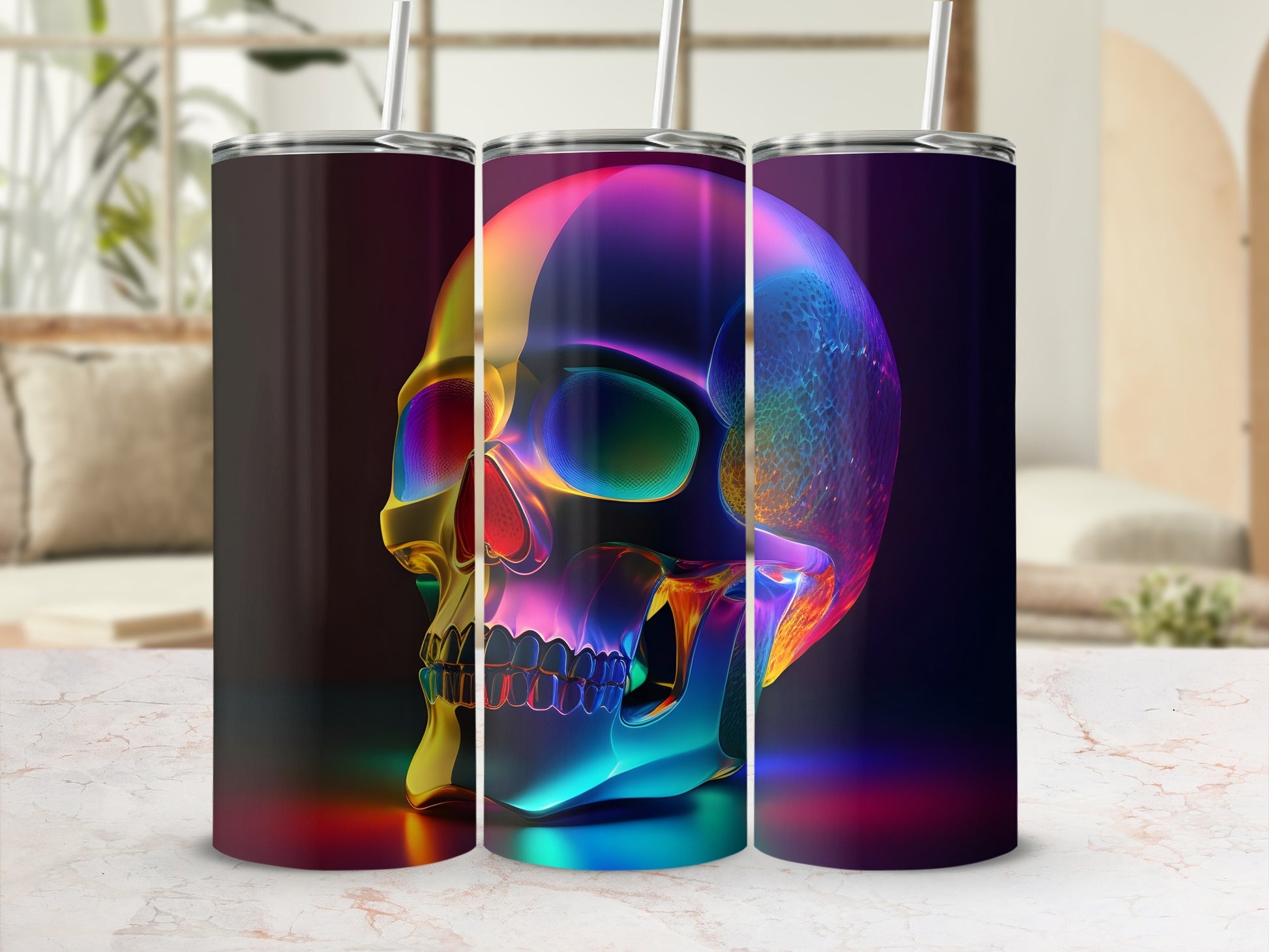 Three colorful, translucent skull tumblers with straws on a marble countertop.