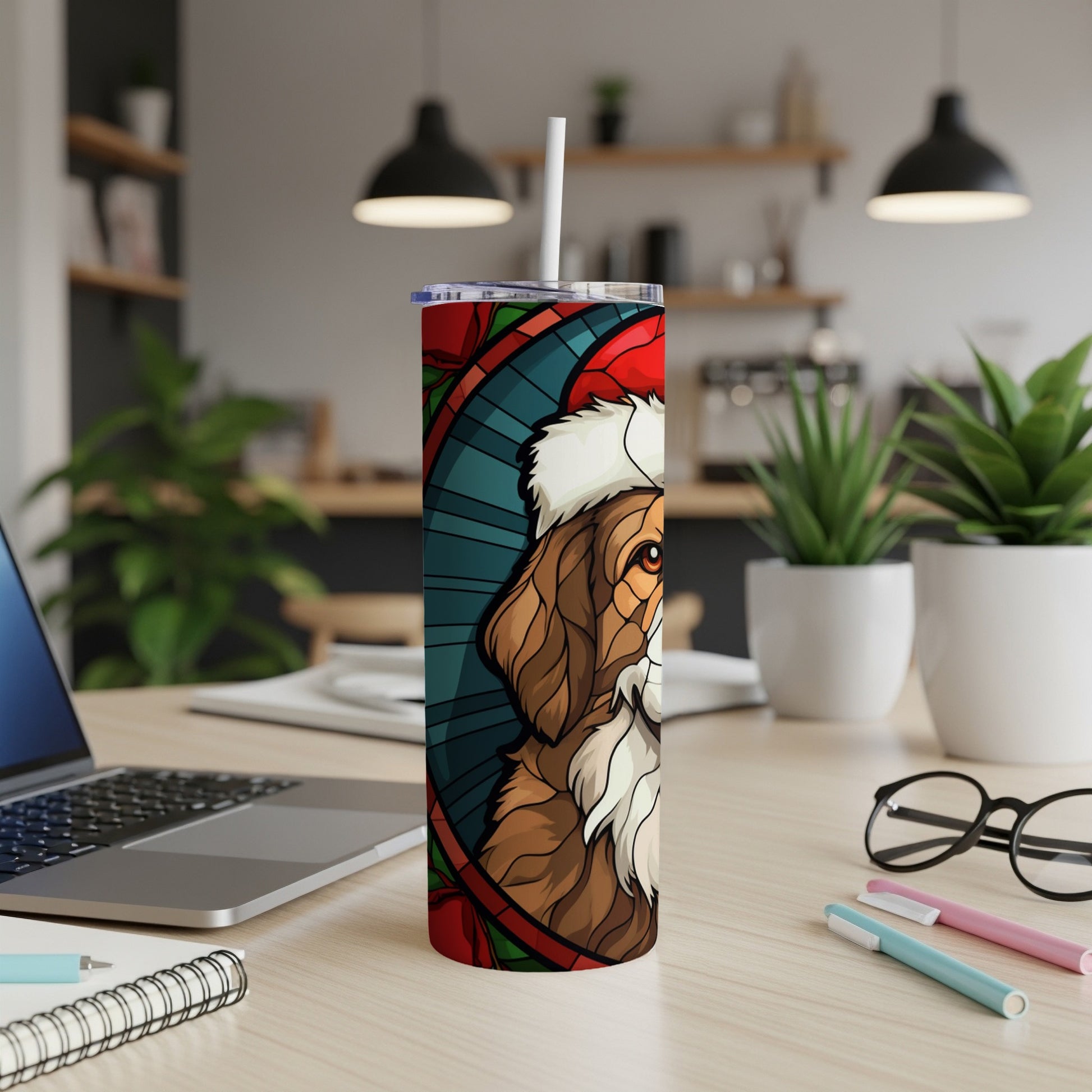 Tumbler with a stylized dog wearing a Santa hat, on a desk.
