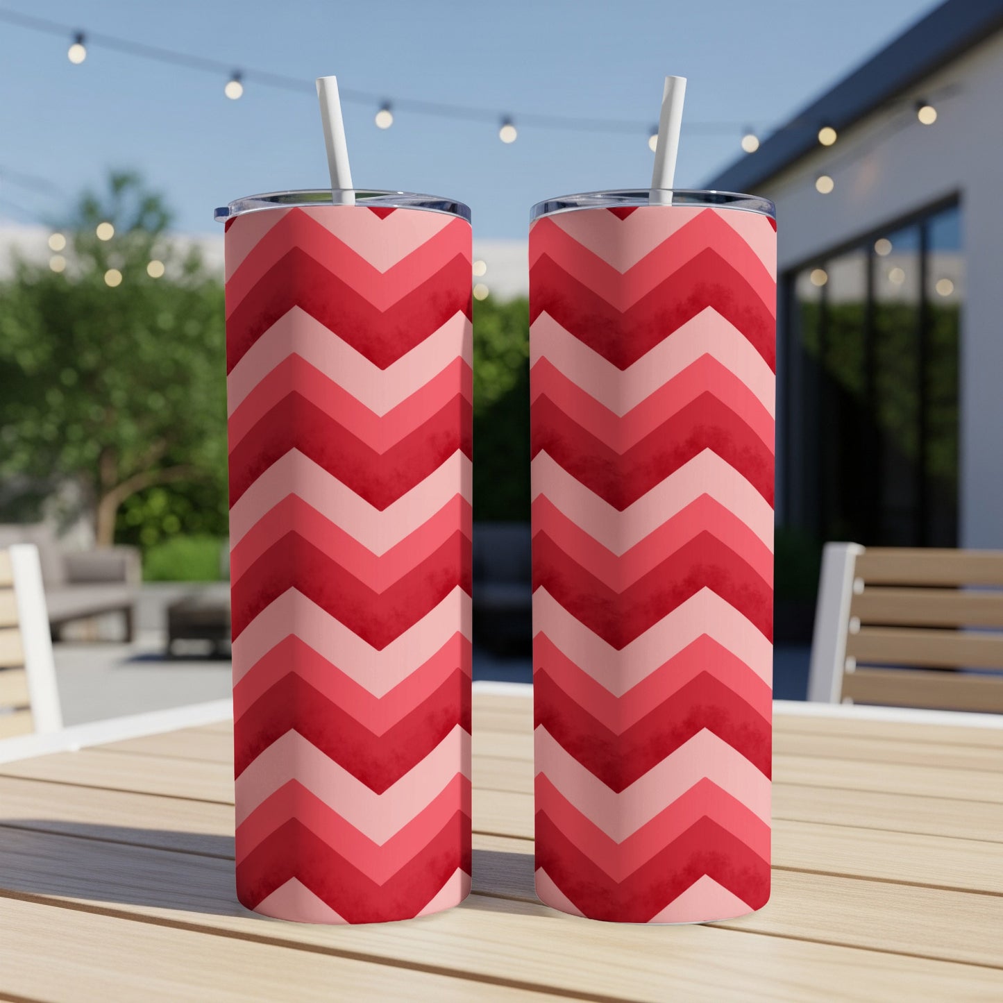 Two tumblers with red and pink chevron patterns on a wooden table.