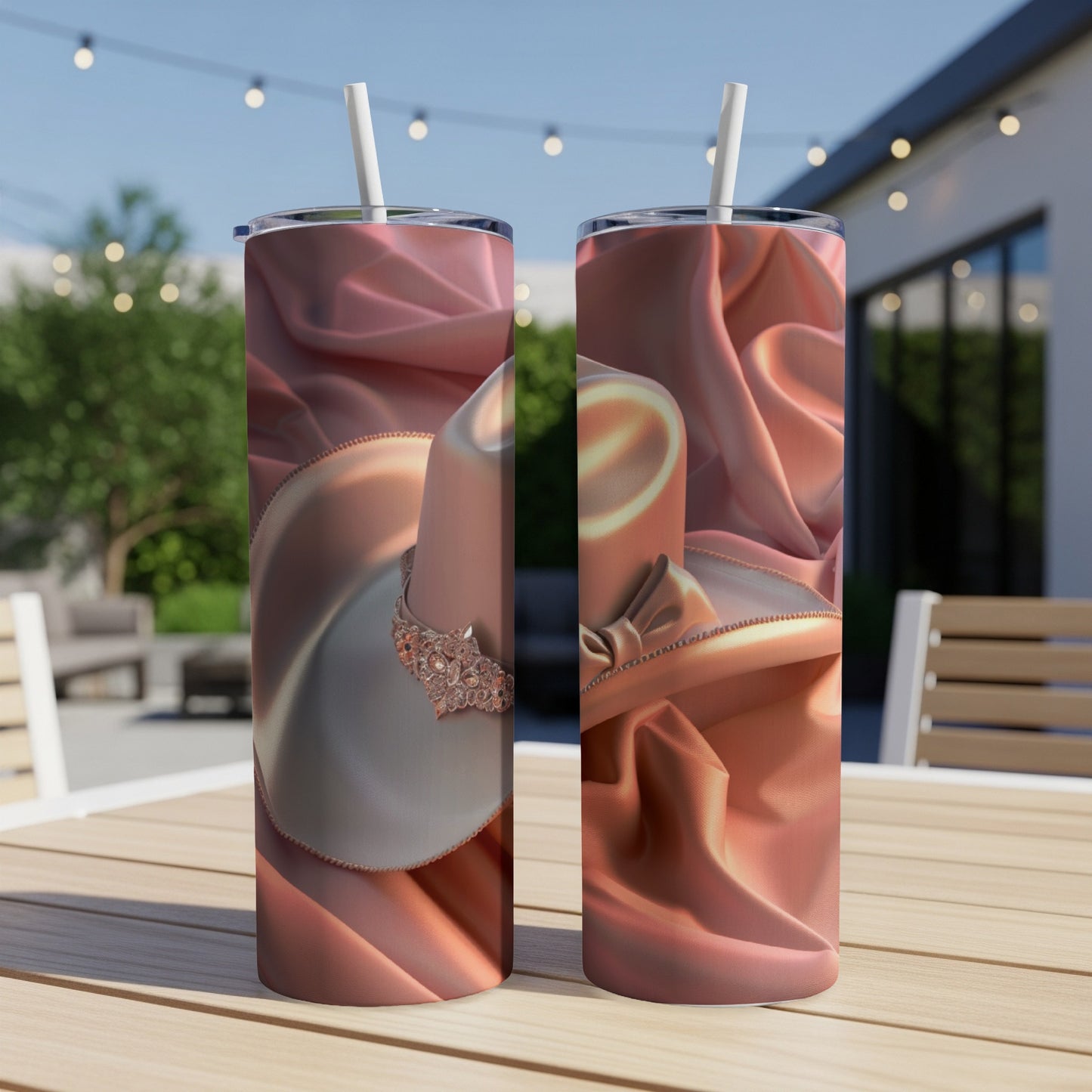 Two tumblers with a satin bow and jeweled detail on a wooden table.