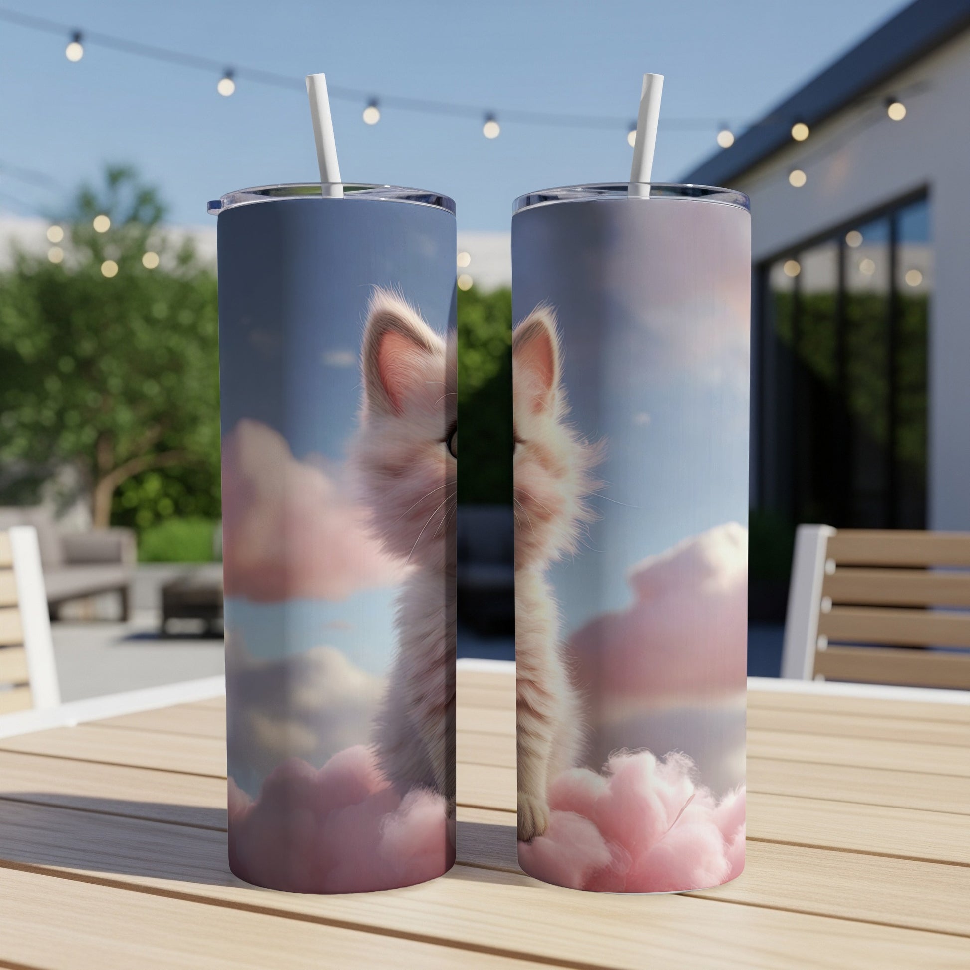 Fluffy white kitten peeking from pink clouds on a patterned tumbler.