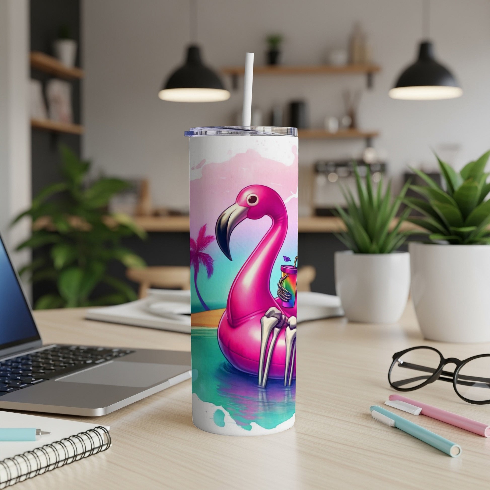 Pink flamingo skeleton tumbler with cocktail on desk.