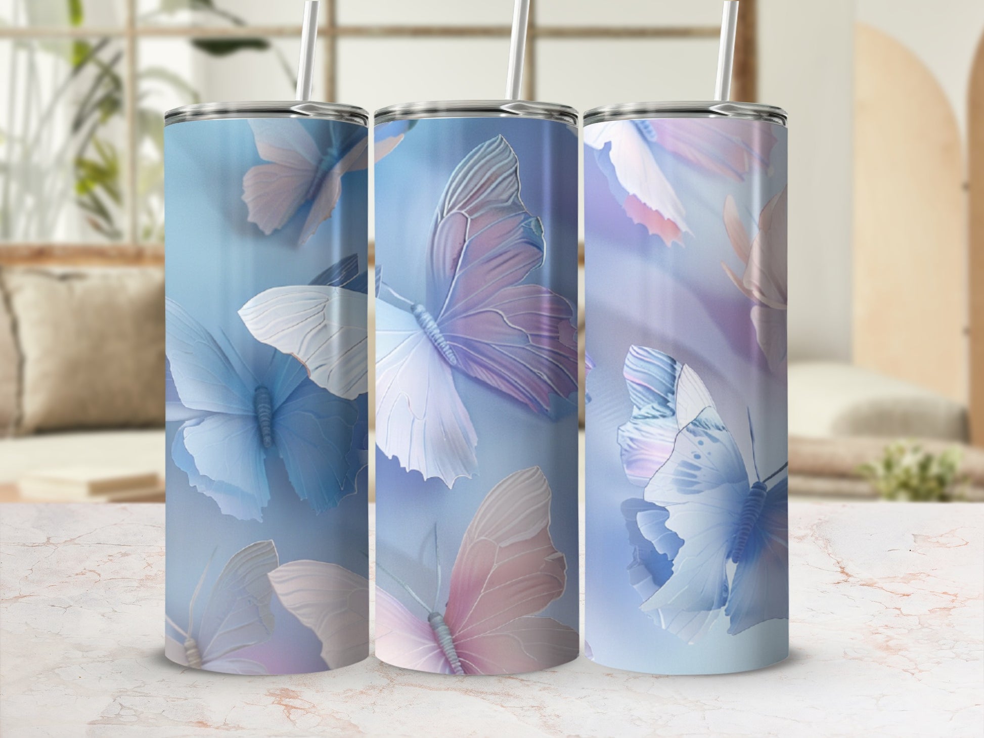 Three tumblers with pastel butterfly designs and reusable straws.