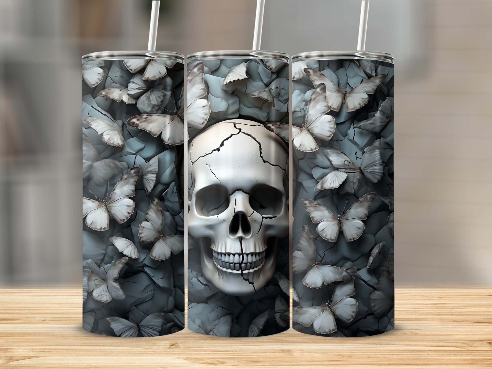 Three tumblers featuring a cracked skull surrounded by white butterflies.